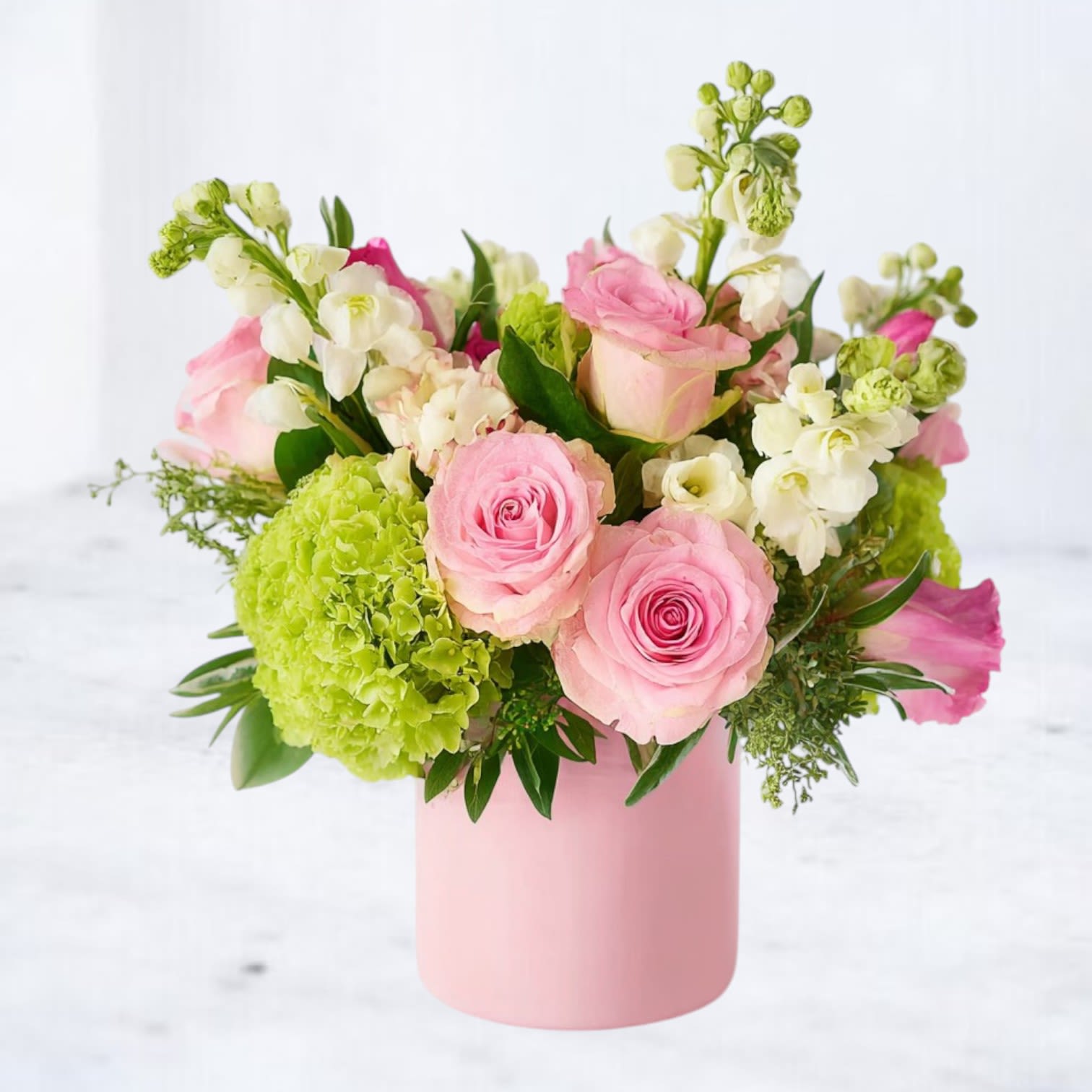 Pink Lemonade Confetti - Bring a splash of joy to any occasion with Pink Lemonade Confetti — a cheerful and refreshing arrangement that blends the sweetness of pink ranunculus, blush roses, creamy stock, and lime-green hydrangeas with playful accents of peach snapdragons and hypericum berries. Hand-designed in a soft pink vase, it’s a modern floral delight bursting with feminine energy and springtime magic.  Whether you're celebrating a birthday, welcoming a new baby, or simply making someone’s day a little brighter, this bouquet delivers happiness in every petal.