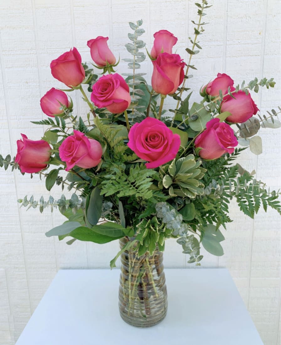 Pink Rose Bouquet - 1 Dozen Long Stem Pink Roses A dozen roses is a timeless gift of love, and the time is always right to give and receive this enchanting gift. Featuring 12 pink long stem roses and greenery loosely designed in a clear glass vase and accented with spiral eucalyptus, it's the perfect gift for birthdays, anniversaries, or just because. The magic of roses will always cast its spell. 