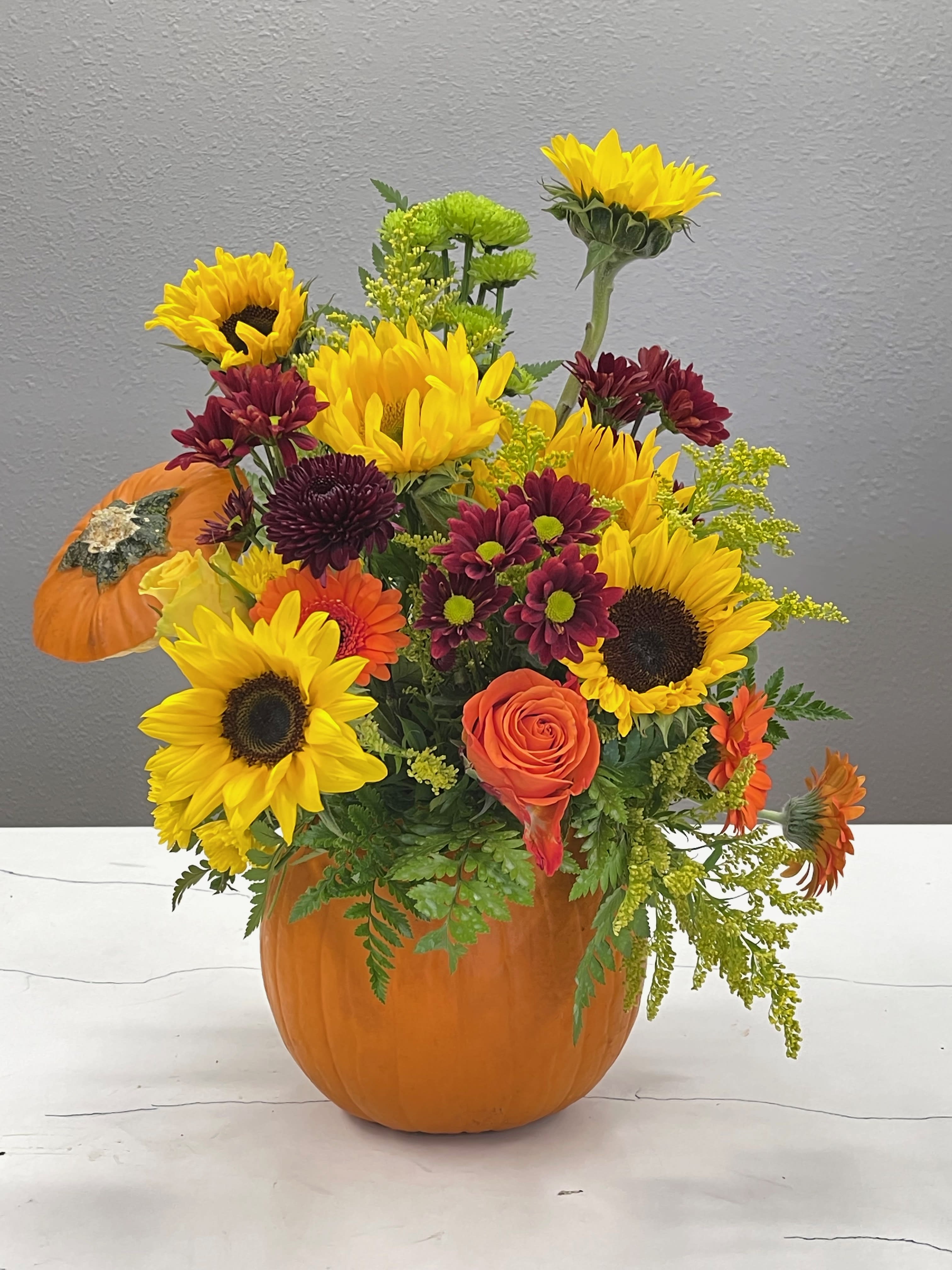Days of Autumn - Invite the joy of the season into your home with bright and cheerful fall flowers bursting out of a natural pumpkin.