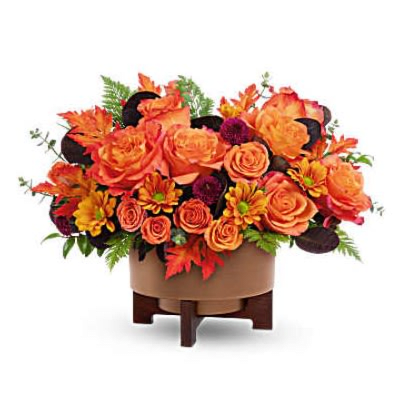 Modern Copper Centerpiece - Modern Copper Centerpiece brings fall to life with rich seasonal blooms, artfully arranged in a sleek metal planter with a warm copper finish and modern wooden stand. A stunning gift or décor piece for Thanksgiving and autumn celebrations This autumn bouquet features light orange roses, orange mini carnations, bronze mums, white waxflower, seeded and spiral eucalyptus, grevillea, and preserved oak leaves. Designed in Modern Copper Planter, it's a warm, modern take on fall-perfect for gatherings or gifting Orientation: All-Around
