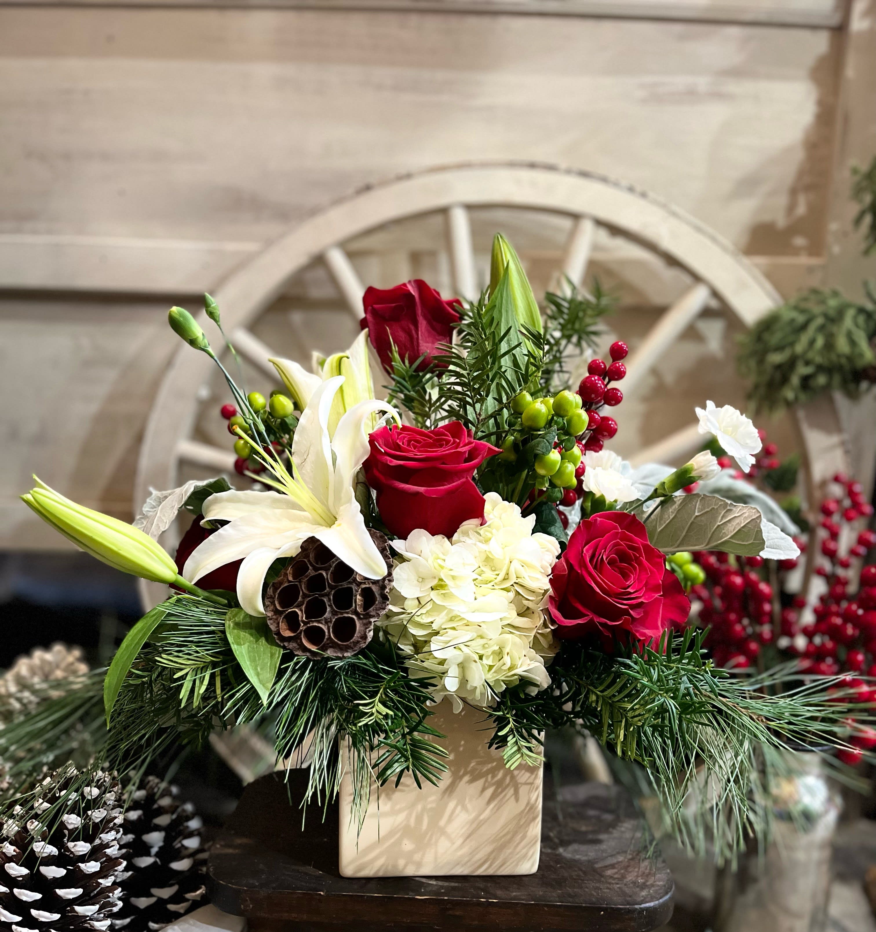 Forest Fresh - This fragrant arrangement combines a lush array of Forest Evergreens, Red Roses, a Lily and berries.  Truly a wonderful way to bring the fragrance of the Forest indoors. SUBSTITUTIONS APPLY FOR CONTAINER &amp; FLOWERS * WILL BE A CLEAR GLASS VASE*