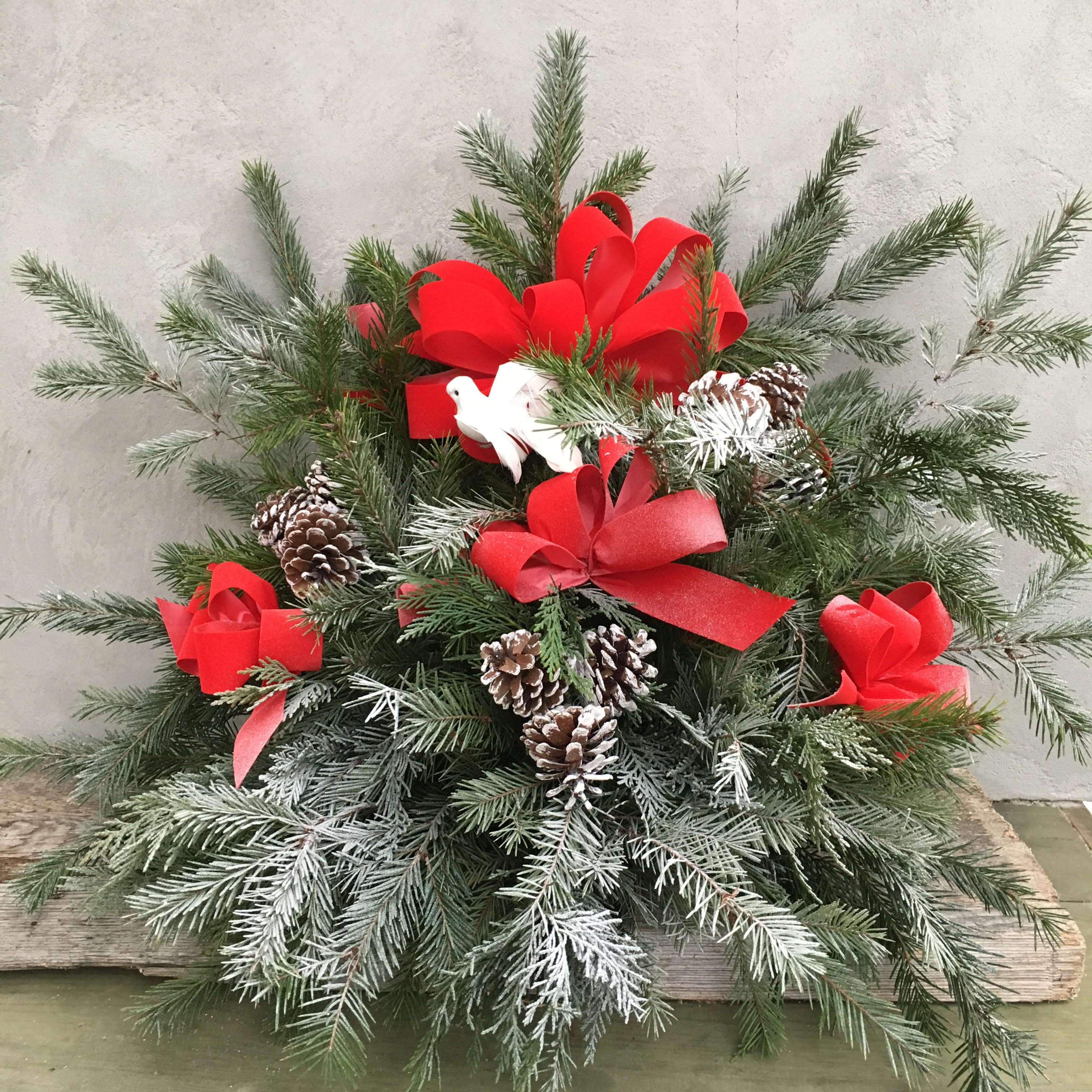 Holiday Remembrance - Remember your deceased loved ones with an arrangement of fresh holiday greenery with velvet bows, pine cones and dove.  Approximately 21&quot; H X 27&quot; W.   We deliver and place on site at local cemeteries.  Please call for more information.