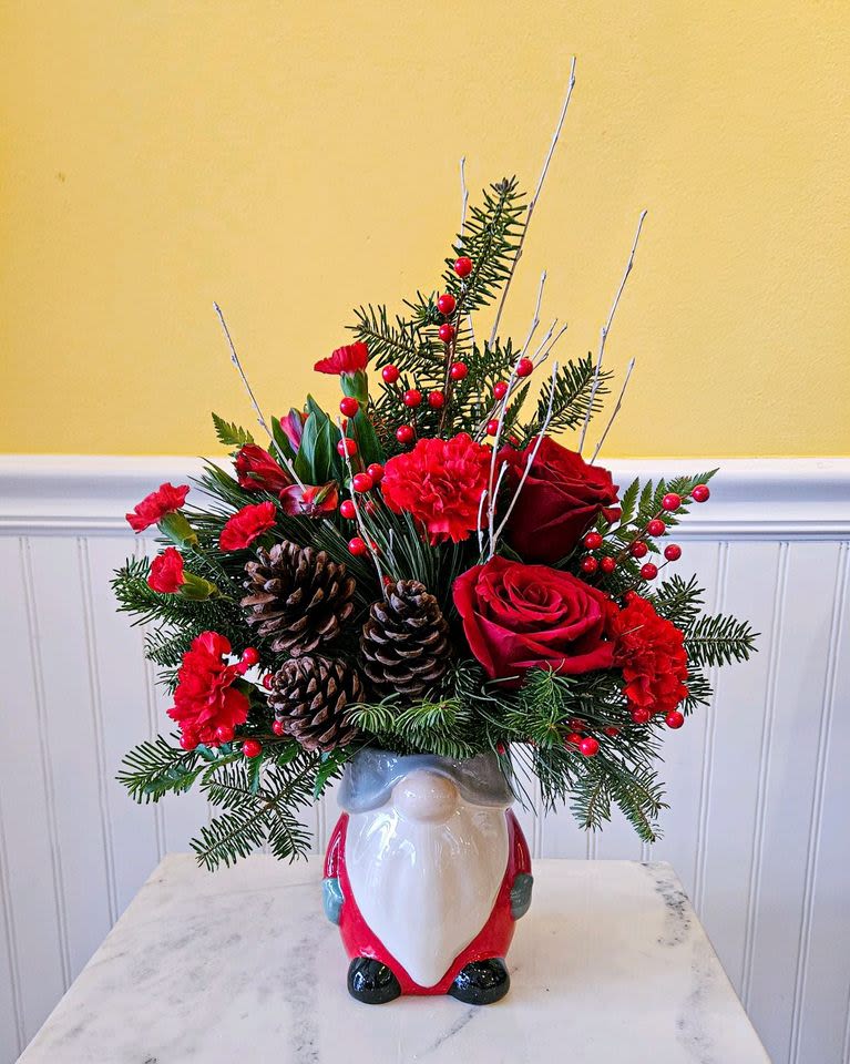 Gnome for the Holiday - Gnome Holiday Cheer Floral Extravaganza  Bring the magic of the holidays into your home with our Gnome Holiday Cheer Floral Extravaganza! This enchanting arrangement features Festive Red and White Blooms that capture the holiday spirit. Evergreen Branches &amp; Holly: Perfect for that seasonal fragrance.  Perfect for holiday gatherings, as a centerpiece, or as a gift to spread cheer, this arrangement is sure to delight and impress. aprox 17 in Z 12 in