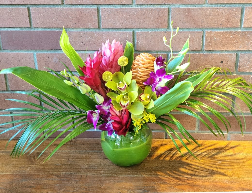 Aloha Friend Bouquet - Welcome to paradise! This arrangement is sure to take you there! Tropical gingers, orchids, cymbidiums, dendrobiums, palms and tropical foliage arranged in a clear green leaf wrapped bubble bowl.