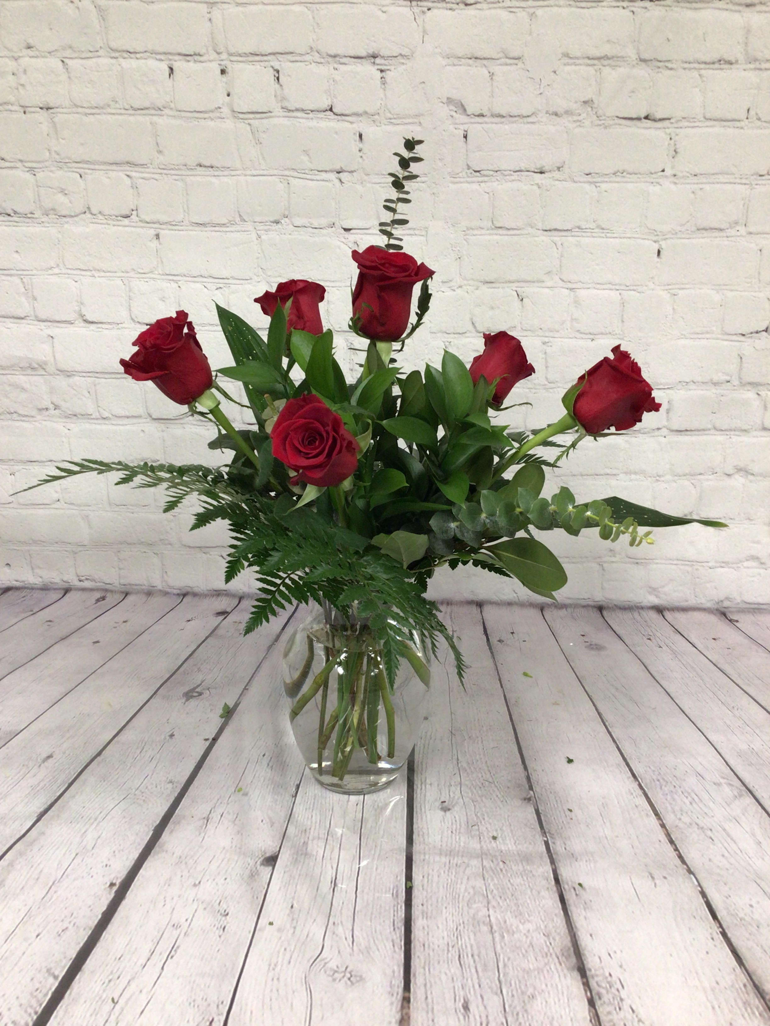 Half dozen red roses arranged - Half dozen red roses with assorted greenery arranged in a vase.