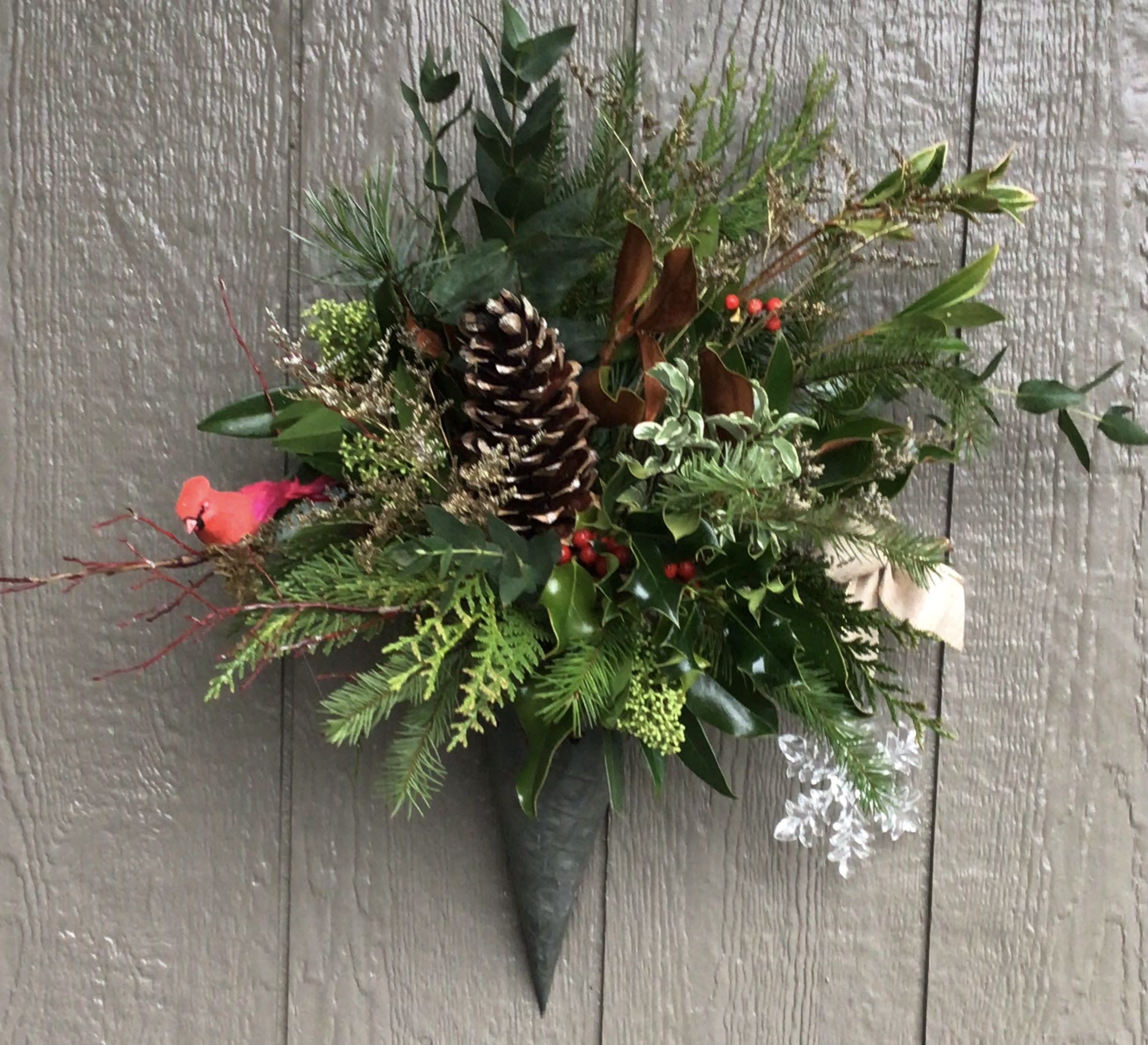 Cardinal Festive Wall Hanger - Filled with festive greens in a metal cone hanger it’s a cardinal nestled on a branch depicting a typical winter scene. ready to hang outside to bring in the Christmas season