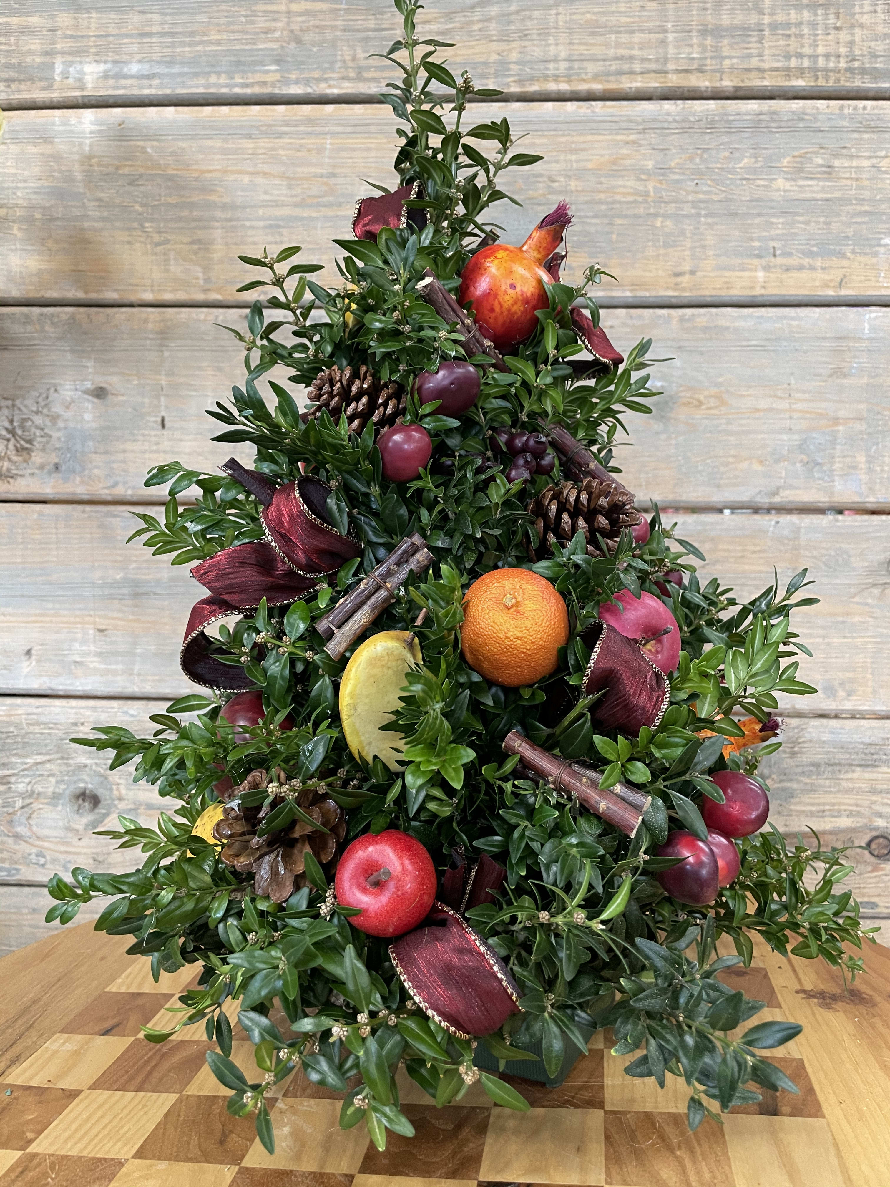 Boxwood Natural Christmas Tree - Put this beautifully made and decorated tree on a small table, mantle or office desk. it is made out of fresh boxwood and decorated with fruit and ribbons. All trees will be a little different from design in picture as they are custom made but will reflect the theme.