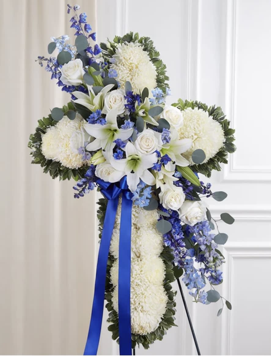 Peace and Prayers Standing Cross  - Standing cross arrangement with white football mums (Chrysanthemum white can be football mums, spider mums or cushion pompons) and Oriental lilies; blue delphinium; accented with silver dollar eucalyptus, assorted greenery and blue ribbon Arrangement measures approximately 42"H x 28"W Appropriate for the funeral home Our florists hand-design each arrangements, so colors and varieties may vary based on local availability Cross create with white and blue on the easel. We delivered 1 hour prior to the service time, please order 2-3 days in advance (Smaller size cross can order by phone call please. it starts with $199.-$299)