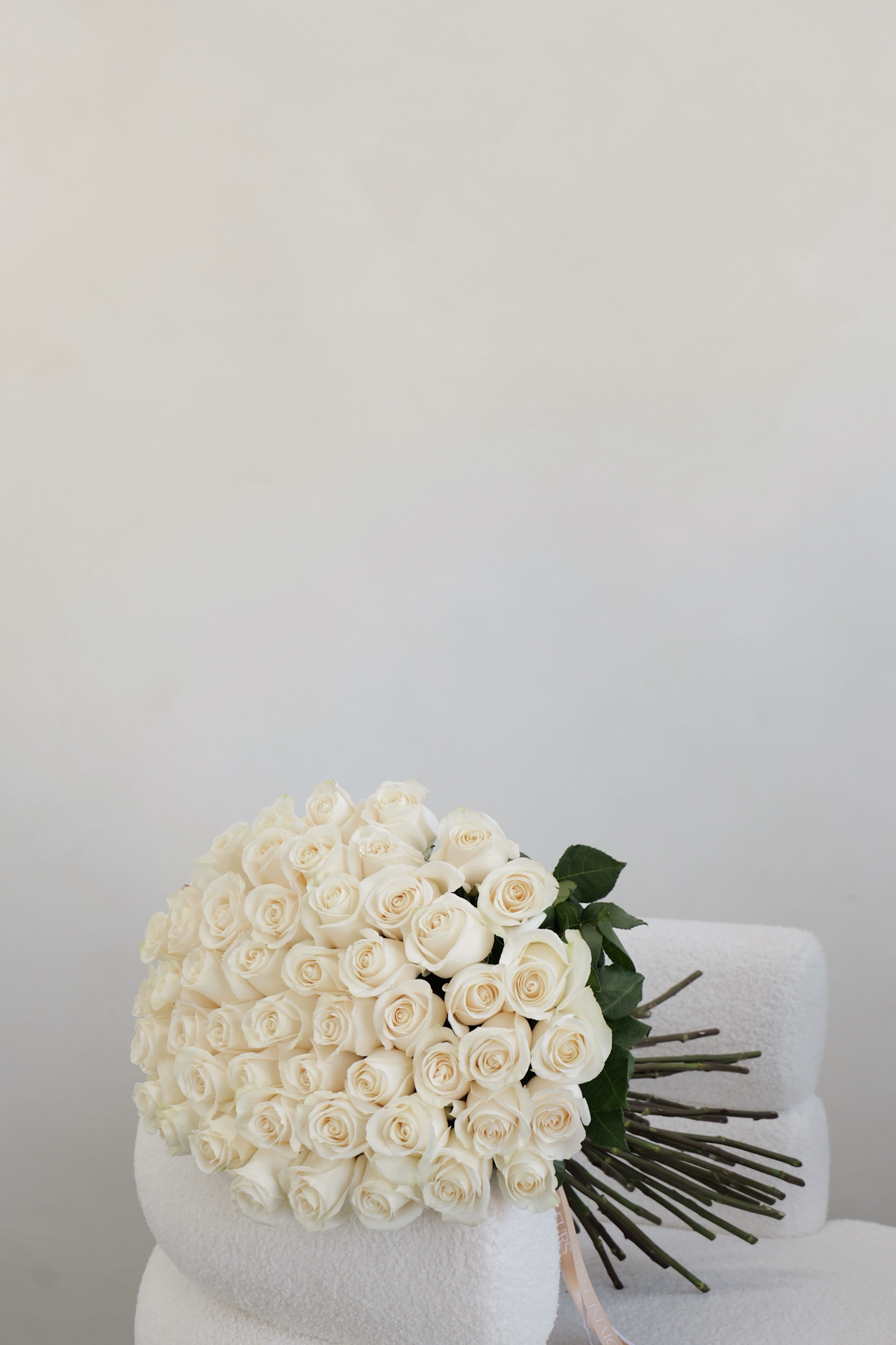 Classic White Rose Bouquet - A timeless and classic bouquet of white roses, beautifully arranged to create a full and elegant look. Each stem is carefully selected for its perfect bloom and pure tone, symbolizing love, sincerity, and new beginnings. A classic choice for any occasion — from weddings to heartfelt gestures of appreciation.  Available in: • 25 roses – Standard • 50 roses – Deluxe (shown in the picture) • 75 roses – Premium