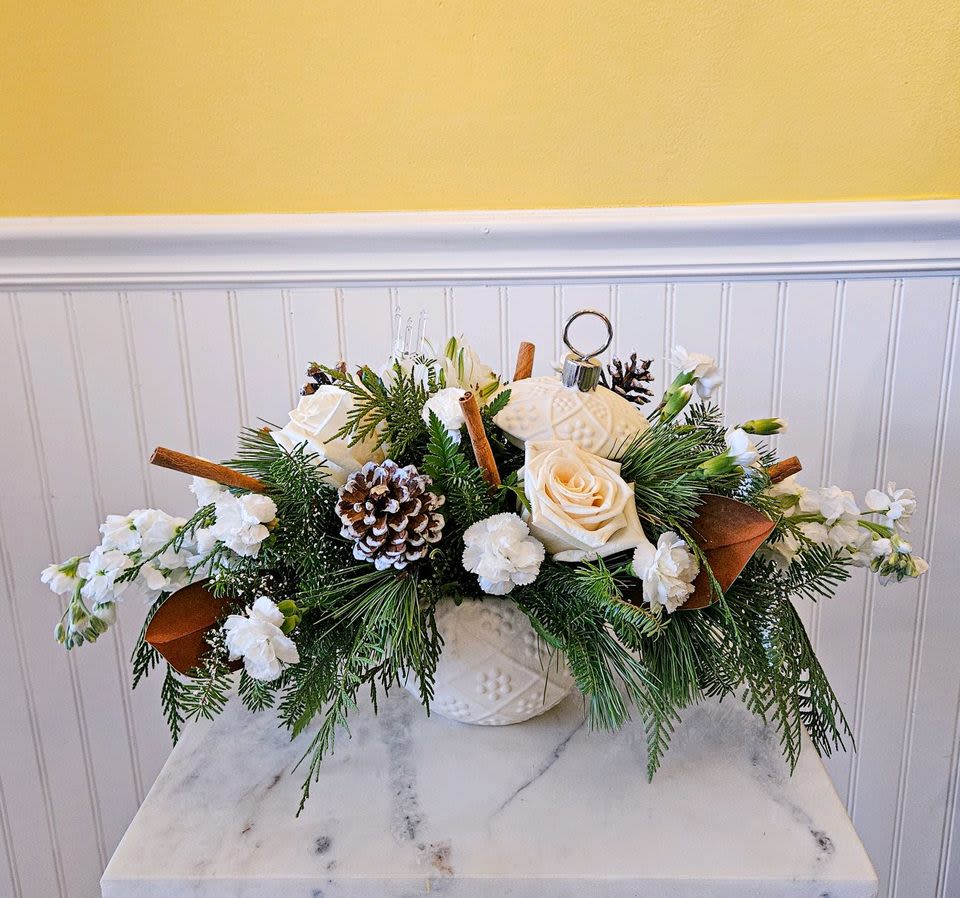 Winter Elegance Bouquet - This arrangement, featuring white blooms, pinecones, cinnamon sticks, and evergreen branches, exudes a festive and sophisticated charm. Perfect for holiday decor or any winter-themed event, its beauty will surely bring warmth and elegance to any setting. Approx 11in X19 in