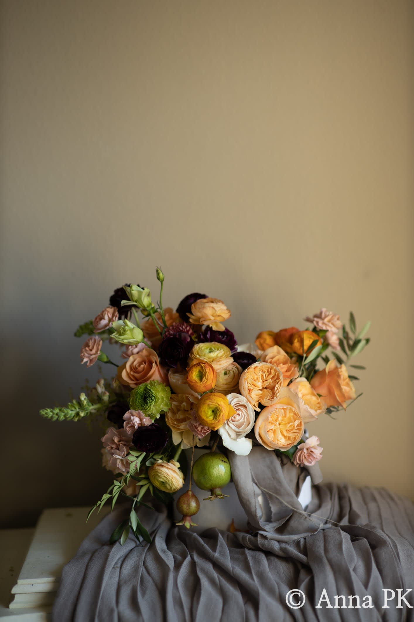 Designer's Choice - Fall Elegance - Floral arrangement in warm hues (orange, yellow, peach, burgundy, etc.) presented in a clear glass or ceramic vessel. (Please note, the arrangement will NOT include fruit.)  Each Designer's Choice vase arrangement will be one of a kind and consist of fresh, seasonal flowers. The arrangement depicted in the photo is just one example of our Designer's Choice Vase Arrangement. Actual arrangement may vary in terms of flower type, color scheme, and overall design depending on seasonal and local availability - but will be similar in size and include flowers of equal value.