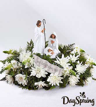 DaySpring® God's Gift of Love Centerpiece 17-C11 - White roses, Star of Bethlehem, chrysanthemums, and mini carnations, surrounded by an assortment of fresh Christmas greens