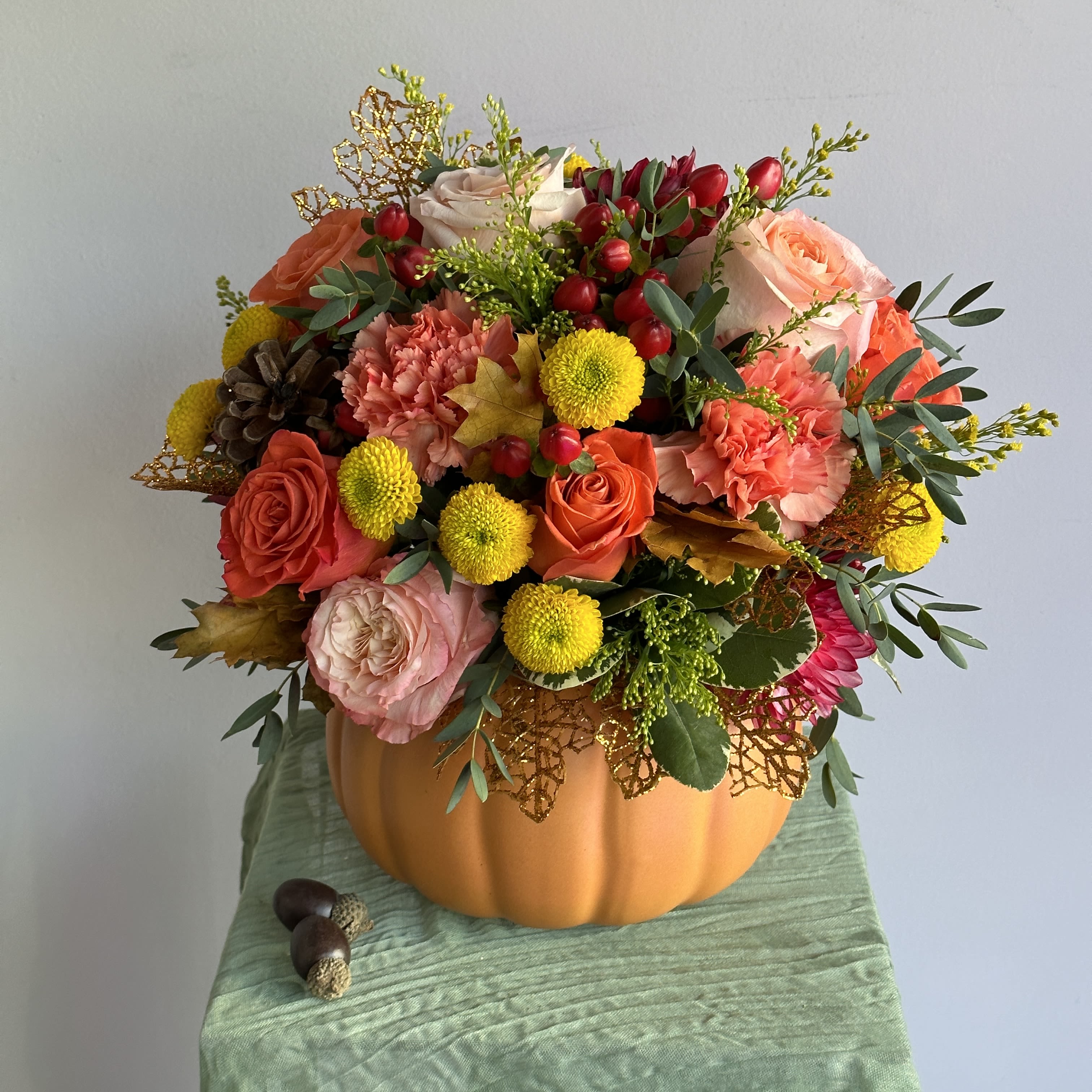 Thanksgiving Arrangement  - Thanksgiving flower arrangements in ceramic pumpkins are a festive and stylish gift idea. These arrangements are perfect for creating a warm, seasonal atmosphere. DELUXE size is in the photo