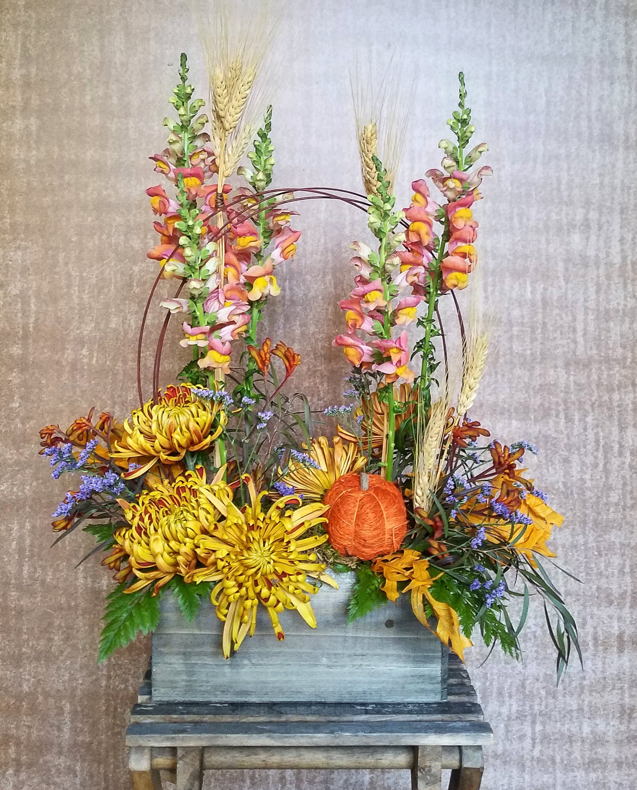 Best seller: Sunshine on the St Croix  - Designer's choice of seasonal cut flowers and accents to include bright and cheery flowers, pussy willow or curly willow, and midolinol arches. Designed in a wooden planter box.   Beautiful seasonal arrangement, hand-arranged and presented in a rustic wooden container.  This arrangement features a beautiful mix of botanical accents and feature foliages. The image shown is an indication of our signature Studio Louise Flowers design style. We will create an arrangement featuring the best of the season in a similar style and color palette.  Flowers are subject to seasonal availability. In the event that any of the flowers are not available, we will substitute them with a similar flower in the same shape, style and color. Standard size pictured. Stem count, container and packaging may vary. The container shown measures approx 5 inches tall.  Stillwater and St Croix Valley delivery.