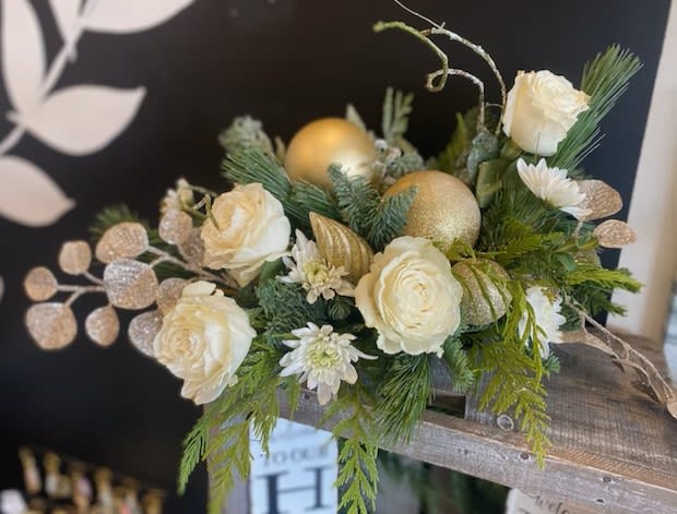 Artic Bloom - An enchanting centerpiece incorporating beautiful Playa Blanca roses, a variety of white blooms, seasonal greens and festive embellishments