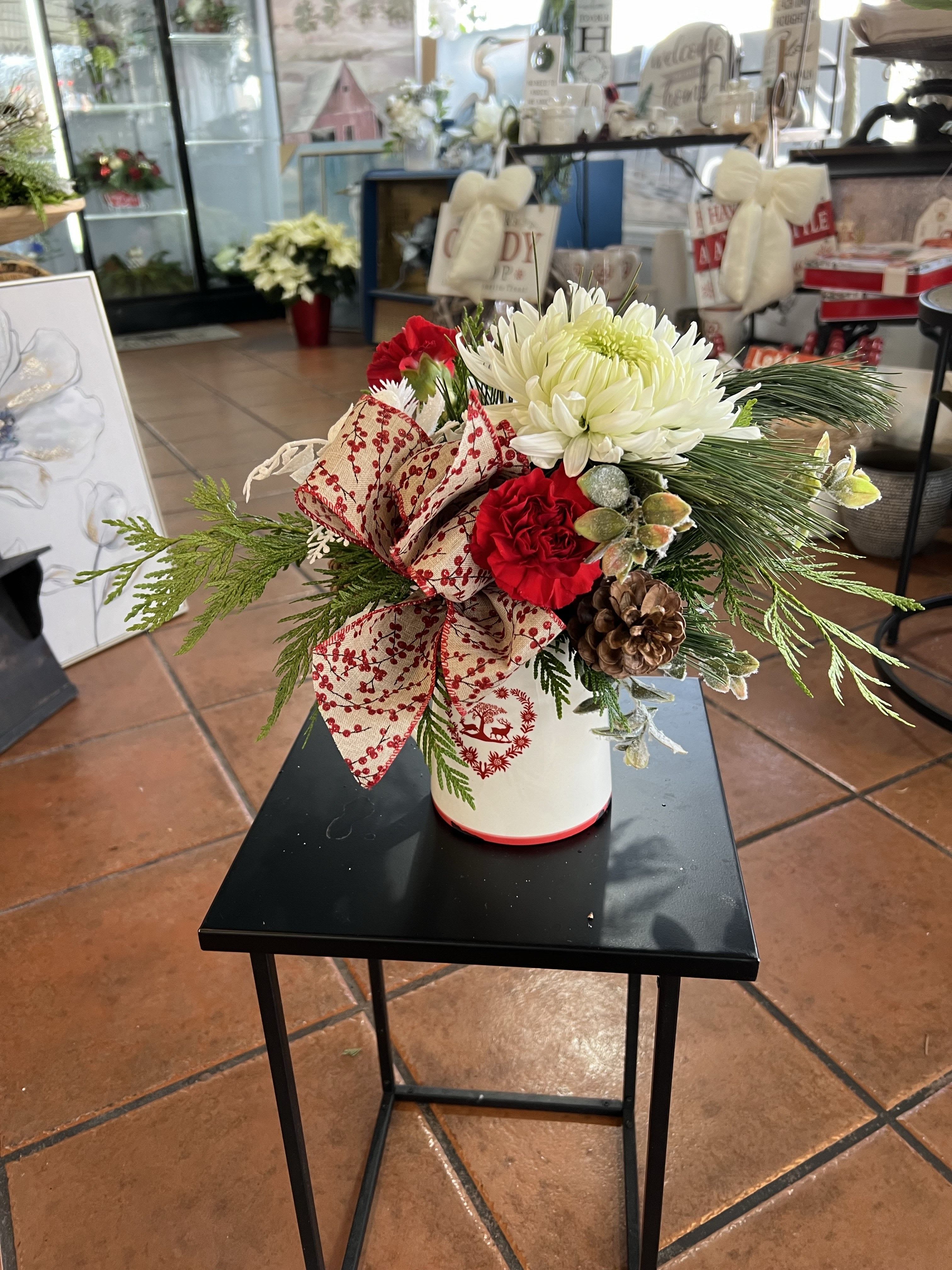 Warm Winter Wishes - A quaint seasonal arrangement incorporating winter greens, fresh blooms and festive embellishments in a keepsake ceramic jug 