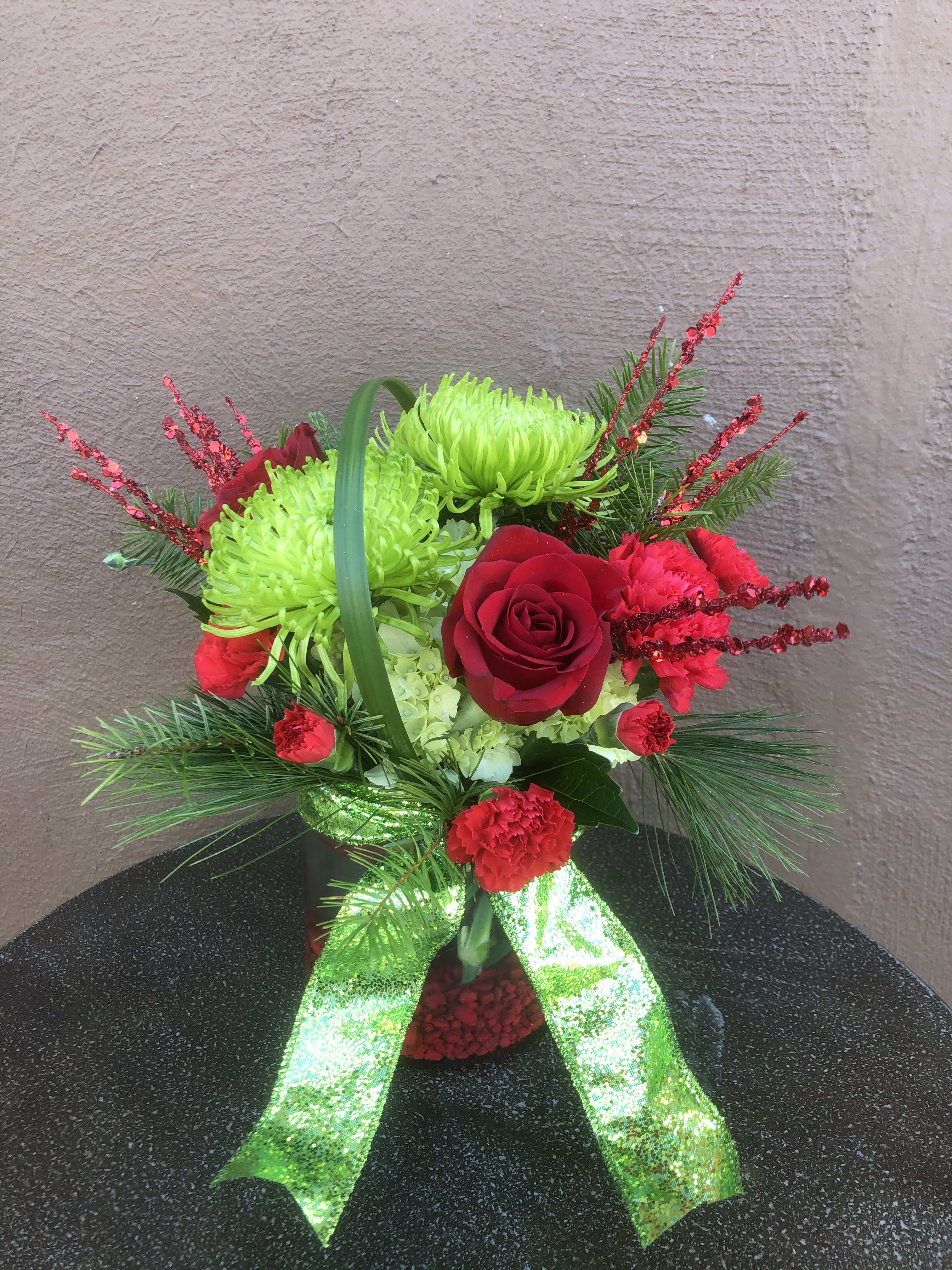 Merry Grinchmas - Green fugi mums, red roses and carnations make this arrangement so much fun with a little added “Grinch”!