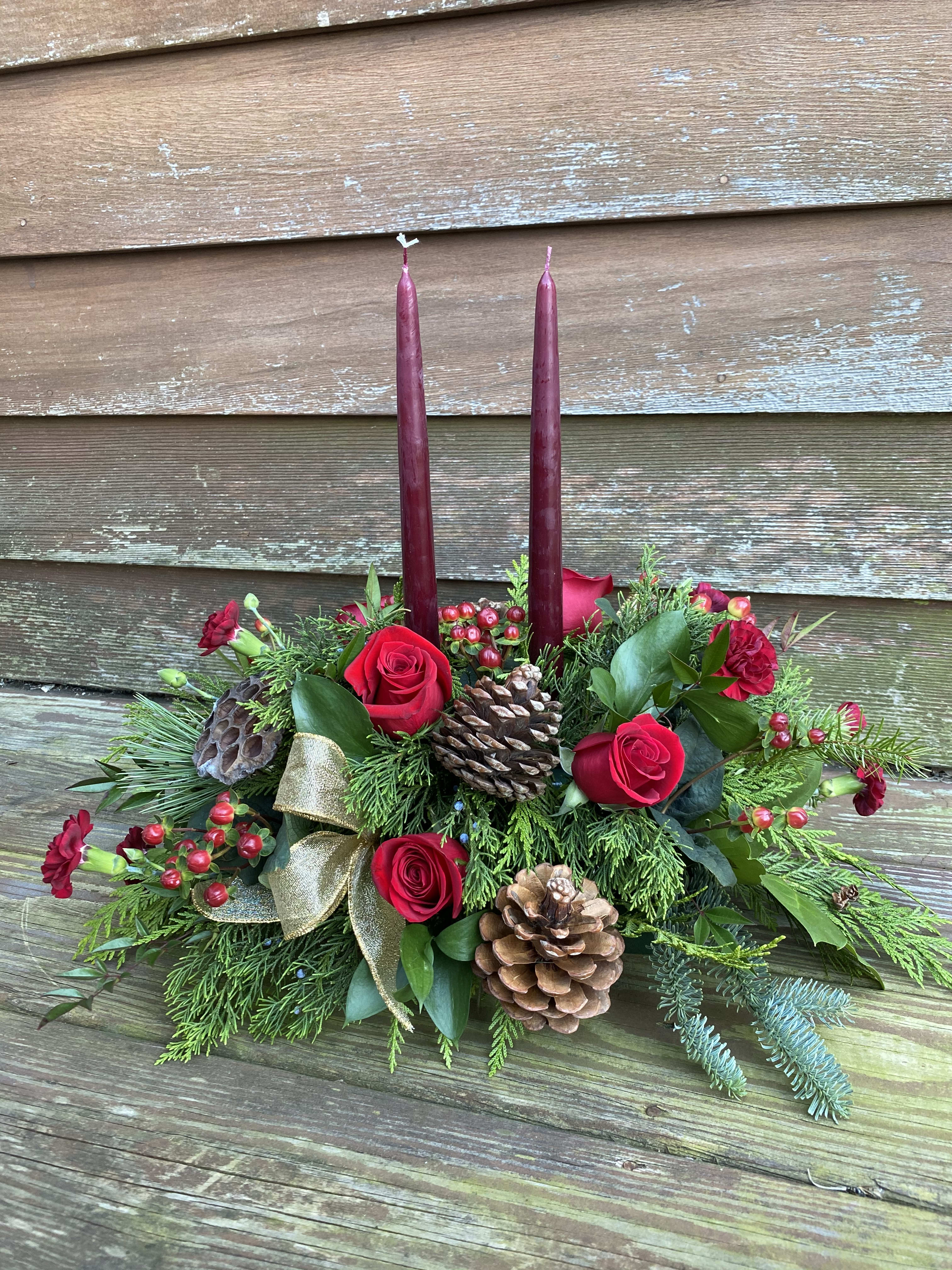 Oblong Centerpiece - Designer's Choice Christmas/Holiday Themed - Flowers included will be designer's choice holiday themed which will include red, burgundy, green, white &amp; cream with textural accents such as pods, ornament balls, ribbon loops etc. Burgundy or basil colored taper candles unless otherwise noted. Length is approximately 20&quot; long. Price shown in photo is standard.