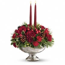 Teleflora's Mercury Glass Bowl Bouquet - A classic holiday centerpiece shines in our signature Mercury Glass Bowl. Festive Christmas greens, red berries and holly mix with red roses and pinecones below glowing red candles for a stunning centerpiece worthy of your celebration.