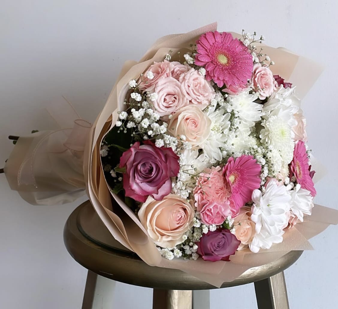 Peachy Pink Bouquet -  Experience the beauty of a stunning bouquet filled with a delightful mix of pink, peachy, and white blooms, elegantly wrapped in a cream packaging. 