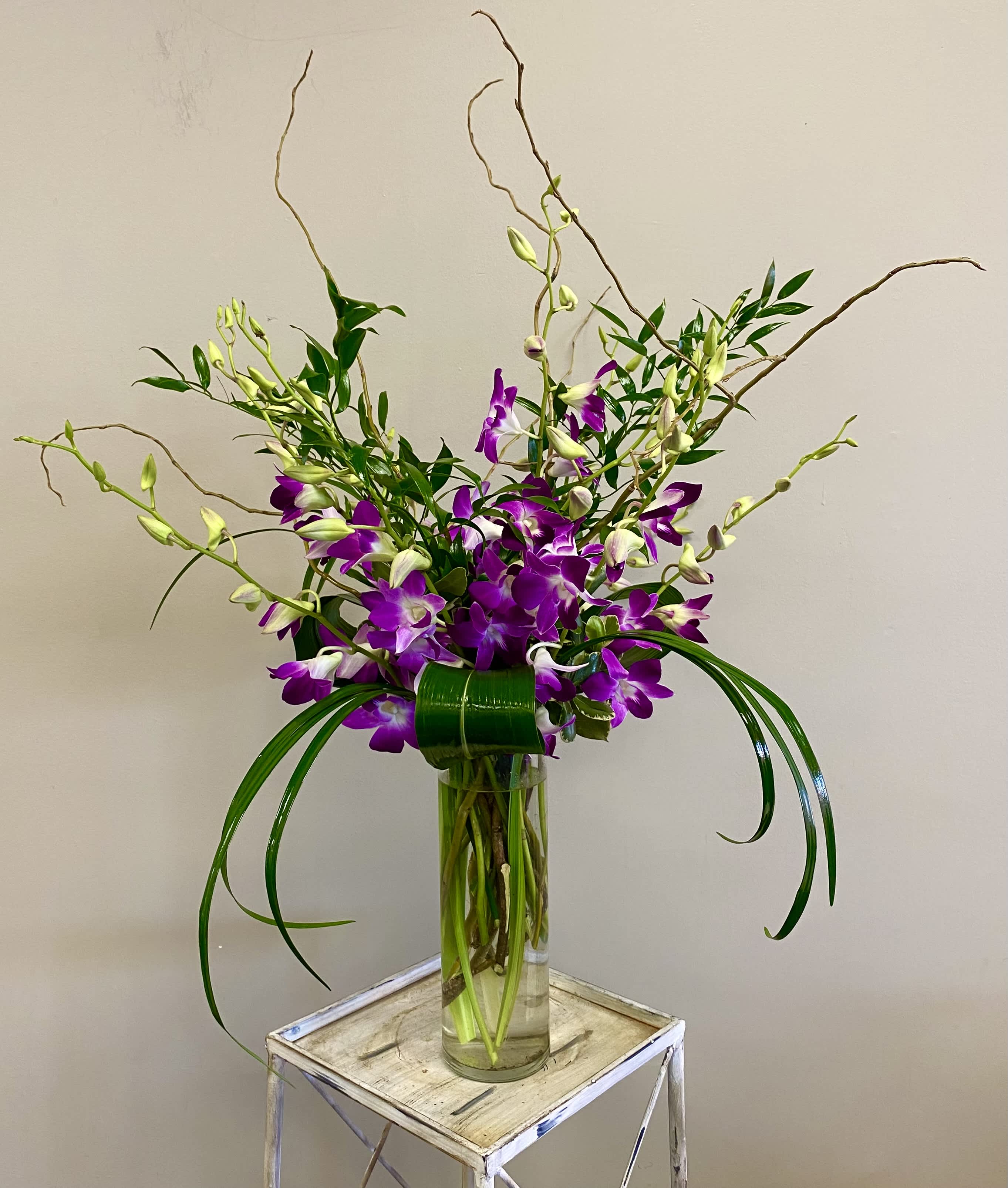 Dendrobium Orchids - There’s nothing quite as pretty as a generous bunch of delicate dendrobium orchids, gathered up and presented in a simple glass vase. With their bright purple-and-white blooms, and adorned with a bit of greenery, it’s a simple gift that will have a big impact.