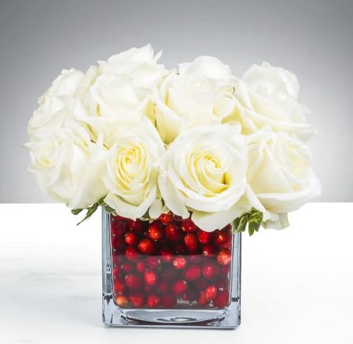 Holiday Secrets By BloomNation™ - Show someone that you care with this arrangement, even if that’s no secret at all. Includes white roses and festive berries.