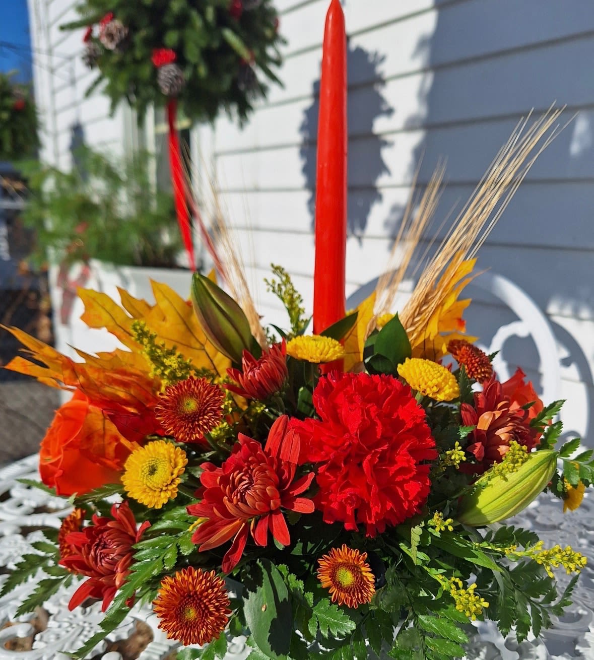  Fall Centerpiece - Single candle centerpiece with carnations, roses, lilies, button poms, faux leaves and wheat