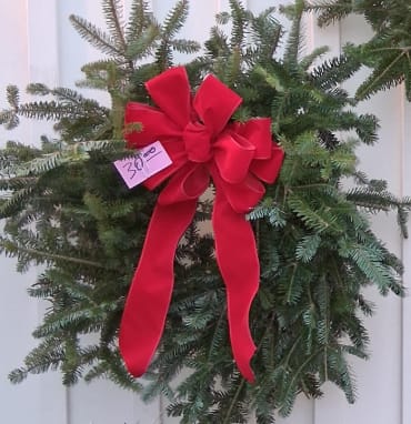 Winter Green Wreath - Welcome the season with this timeless wreath crafted from lush, fragrant winter greens. Designed with layers of fresh evergreens, its natural texture and full shape create a warm and inviting statement for any door or wall. Finished with a beautiful, elegant bow, this wreath blends classic charm with seasonal cheer—perfect for adding a touch of winter magic to your home or gifting to someone special.