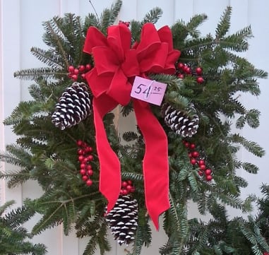 Winter Elegance Wreath - Elevate your holiday décor with this luxurious winter wreath, abundantly crafted from premium, fragrant evergreens. Rich textures of layered winter greens form a lush, full base, adorned with natural pinecones and clusters of seasonal berries for a refined touch of color and charm. Finished with an opulent, designer-quality bow, this wreath brings a sense of timeless sophistication to any door or mantle. A stunning statement piece that captures the beauty and grace of the winter season.