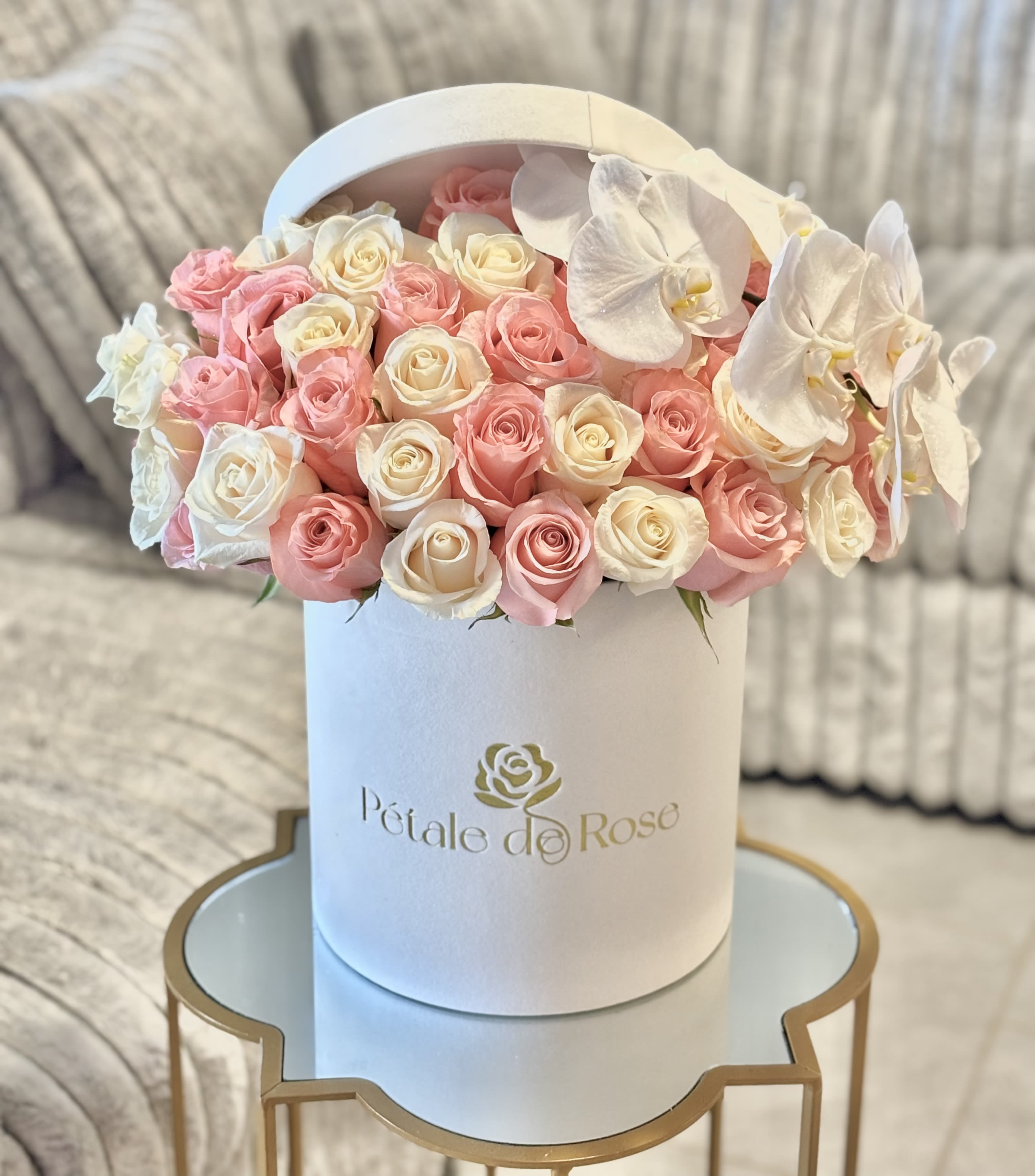 La Vie en Rose - A timeless arrangement featuring 30-35 fresh pink and white roses complemented by elegant white orchids, beautifully presented in our signature Pétale de Rose luxury box. Each bloom is carefully selected to create an exquisite and romantic display — perfect for celebrating love, gratitude, or simply life’s beautiful moments.   Note: Pink rose shades may vary slightly depending on seasonal availability.