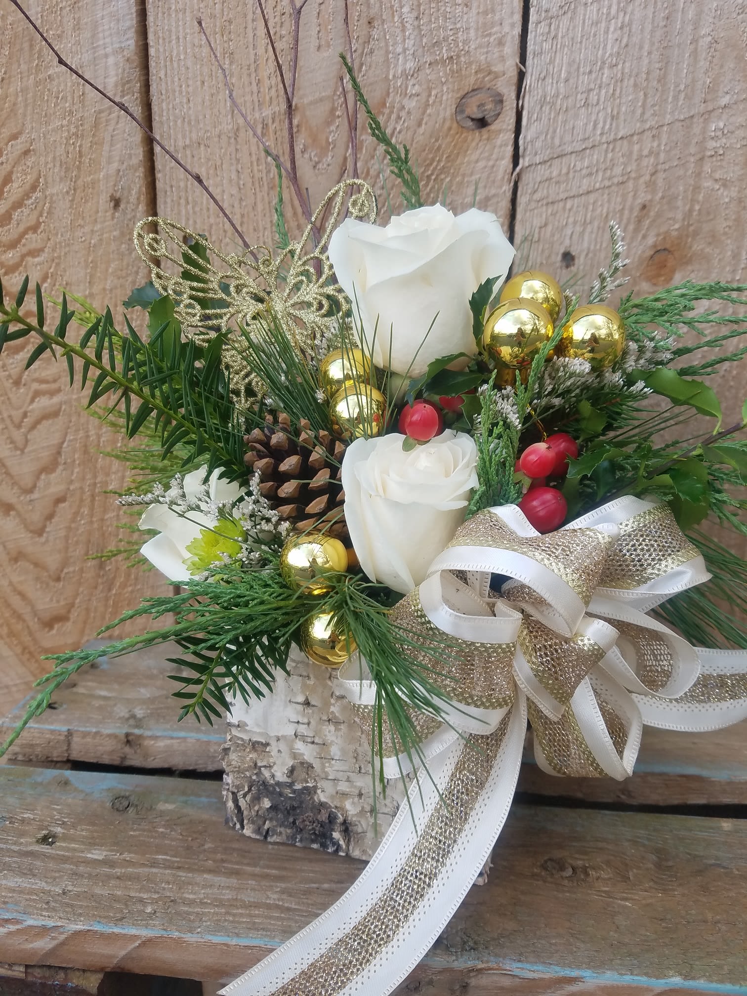 Country Glamour - A touch of rustic, a touch of county and a touch of glam are all combined in this birch wrapped box filled with holly, pine, boxwood, ivory roses, hypericum berries and a glamorous gold and ivory bow!
