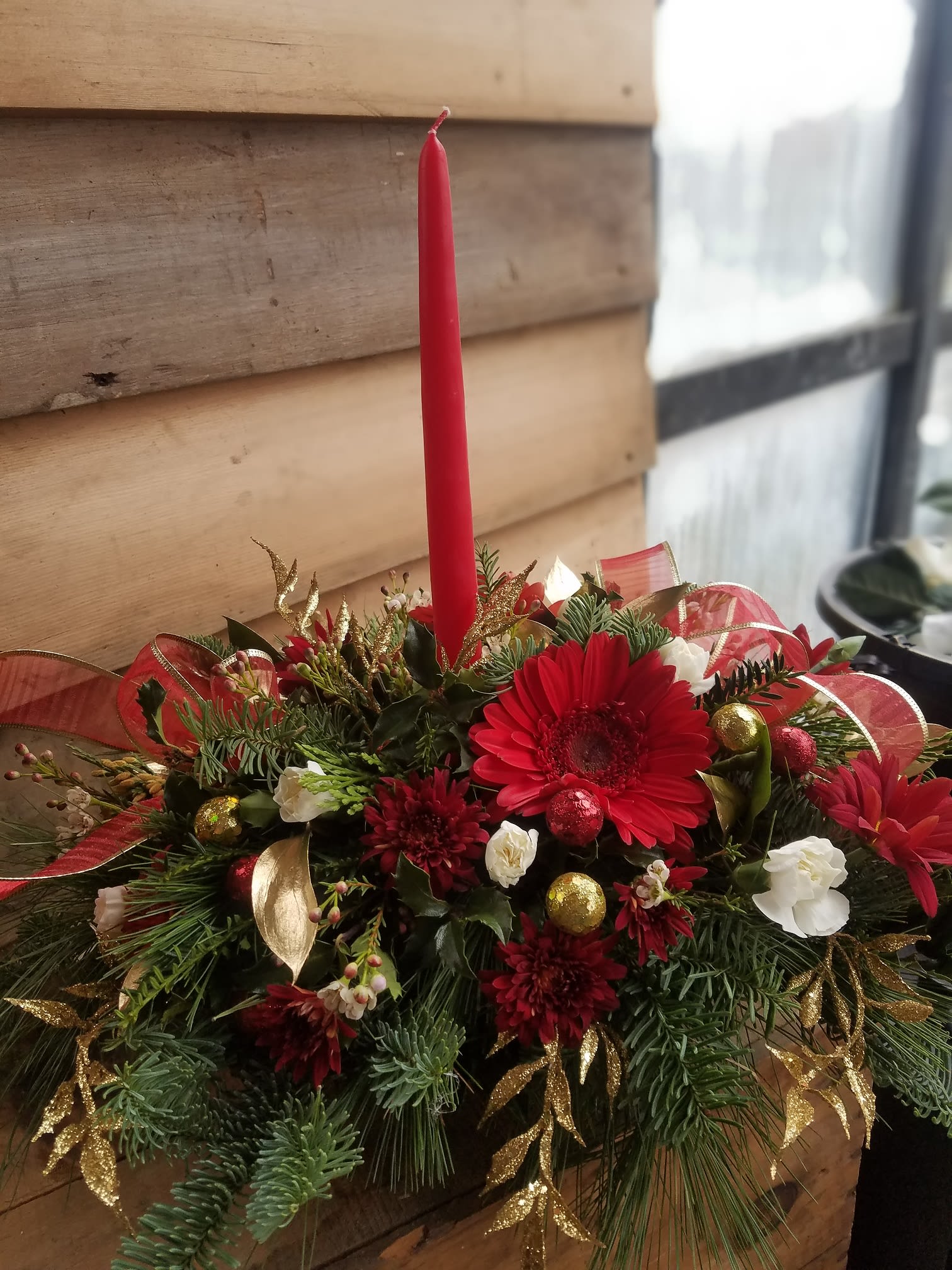 Holiday Glamour - A glamorous holiday centerpiece complete with candles. Full and lush with flowers, greens and accents to provide a show stopping display to your table this holiday season.