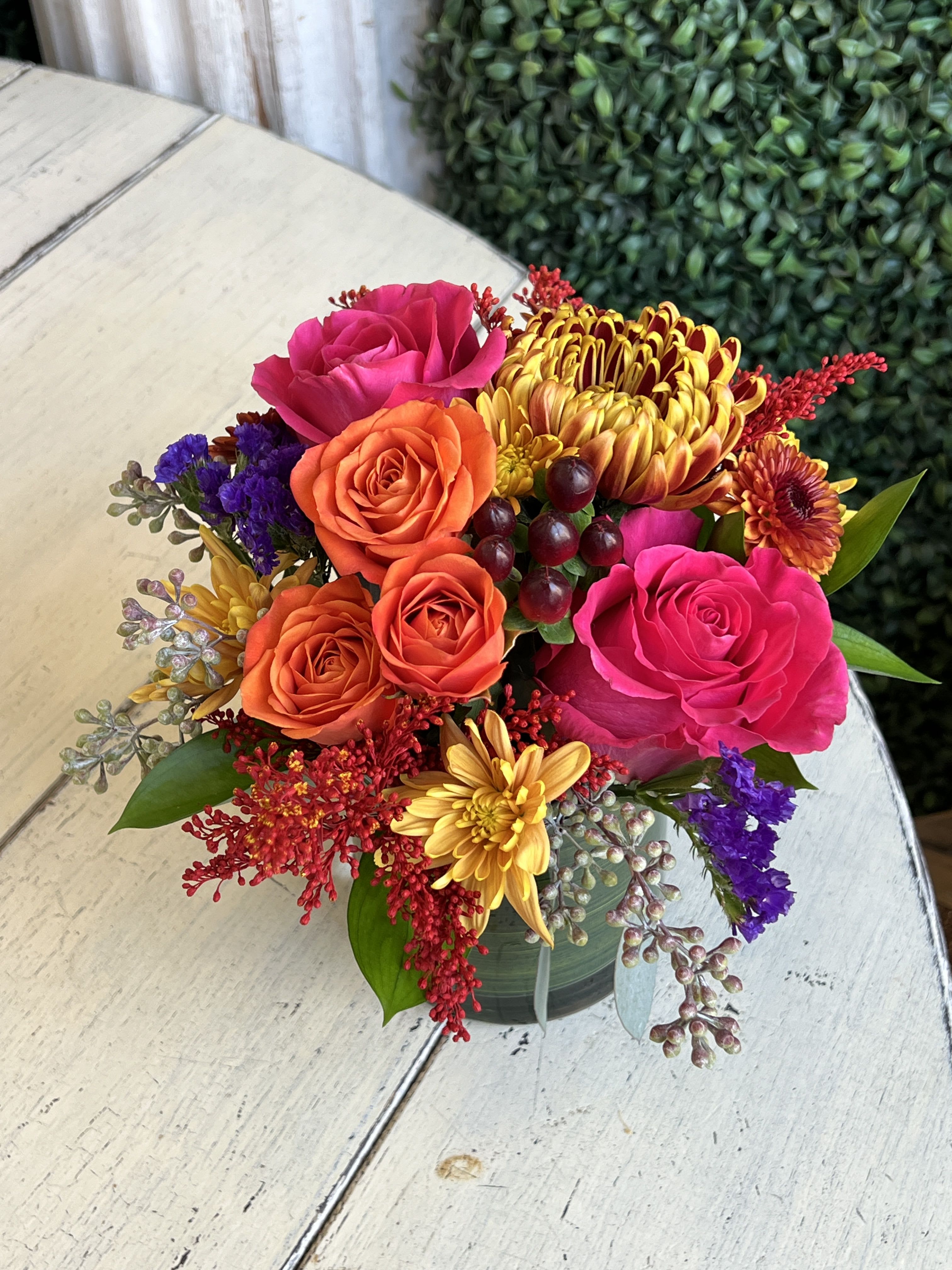 FL-25-03 - Fall Coloreded Cremon, Daisy &amp; Buttons, Hot Pink Roses, Orange Spray Roses, Hypericum, Tinted Solidego and Assorted Foliage in Glass Cylinder Vase.