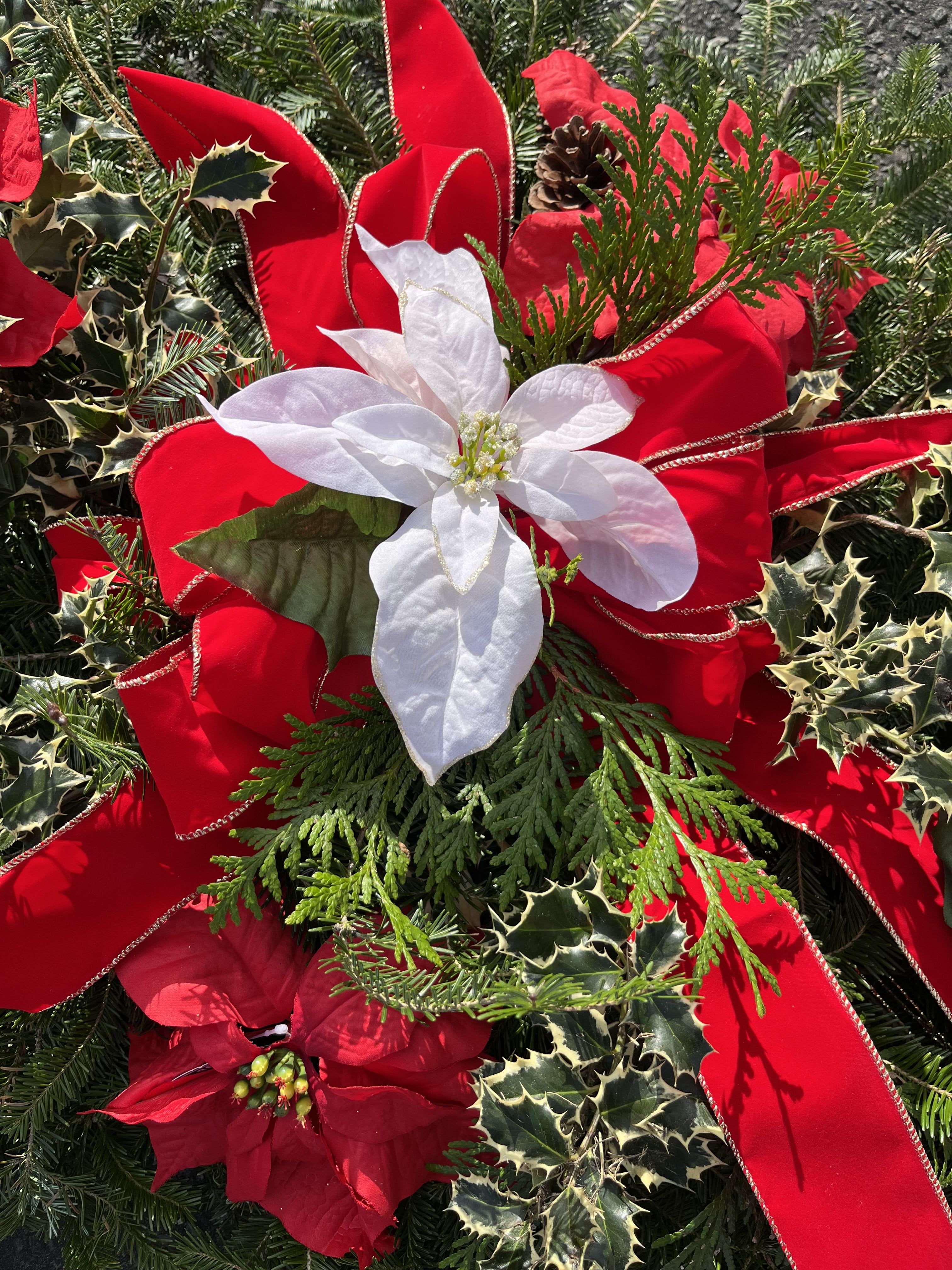 Designers Choice Grave Blanket - Blanket your loved one in beautiful warmth this holiday accent. Let our designers mix the freshest assorted greens, holly, natural and artificial accents in the colors of the season.