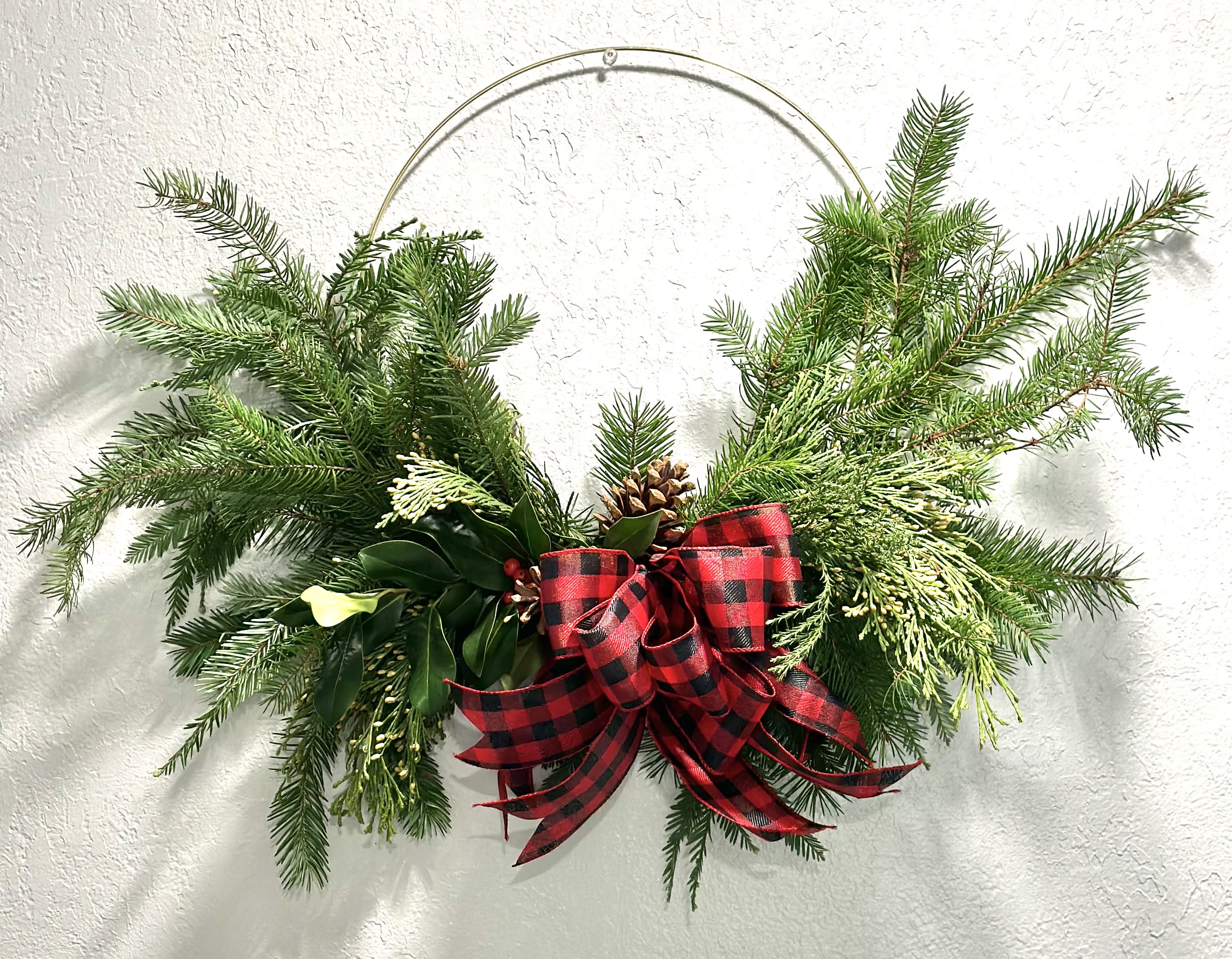 Country Christmas Wreath - This beautiful wreath is created on a gold or silver ring, with Christmas Greens, Pinecones and a bow.  Premium upgrades with Ornaments. 