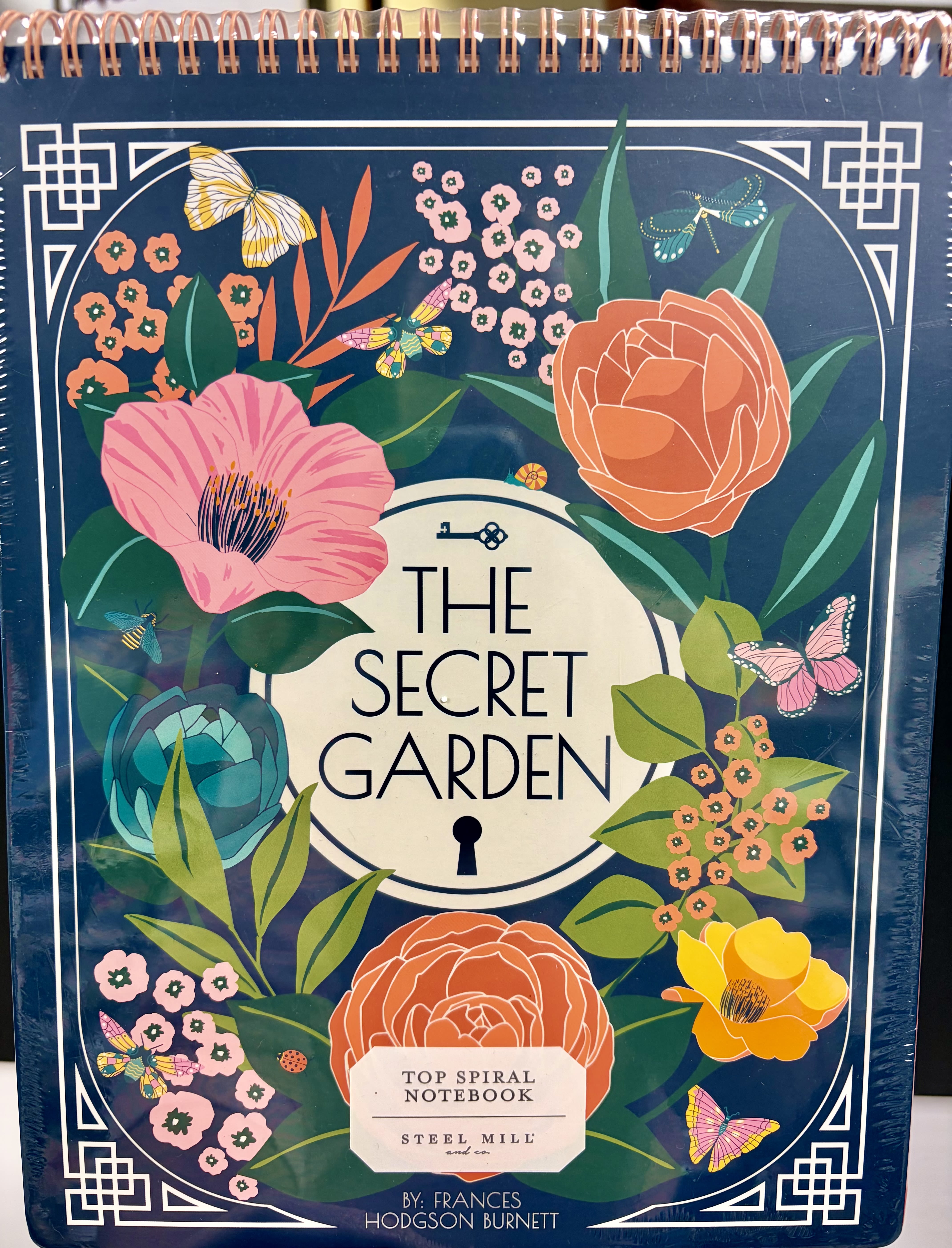 Gift Set: Secret Garden Themed Notebook - Elevate your note taking experience with this floral-themed top spiral notebook. It includes 160 college-ruled pages, double spiral binding, perforated pages, and an interior pocket. This one subject, hardcover notebook is complete with a cover inspired by Frances Hodgson Burnett's novel, The Secret Garden.  11" (27.94 cm) x 8.5" (21.59 cm) 160 lined pages Metal spiral binding Interior pocket