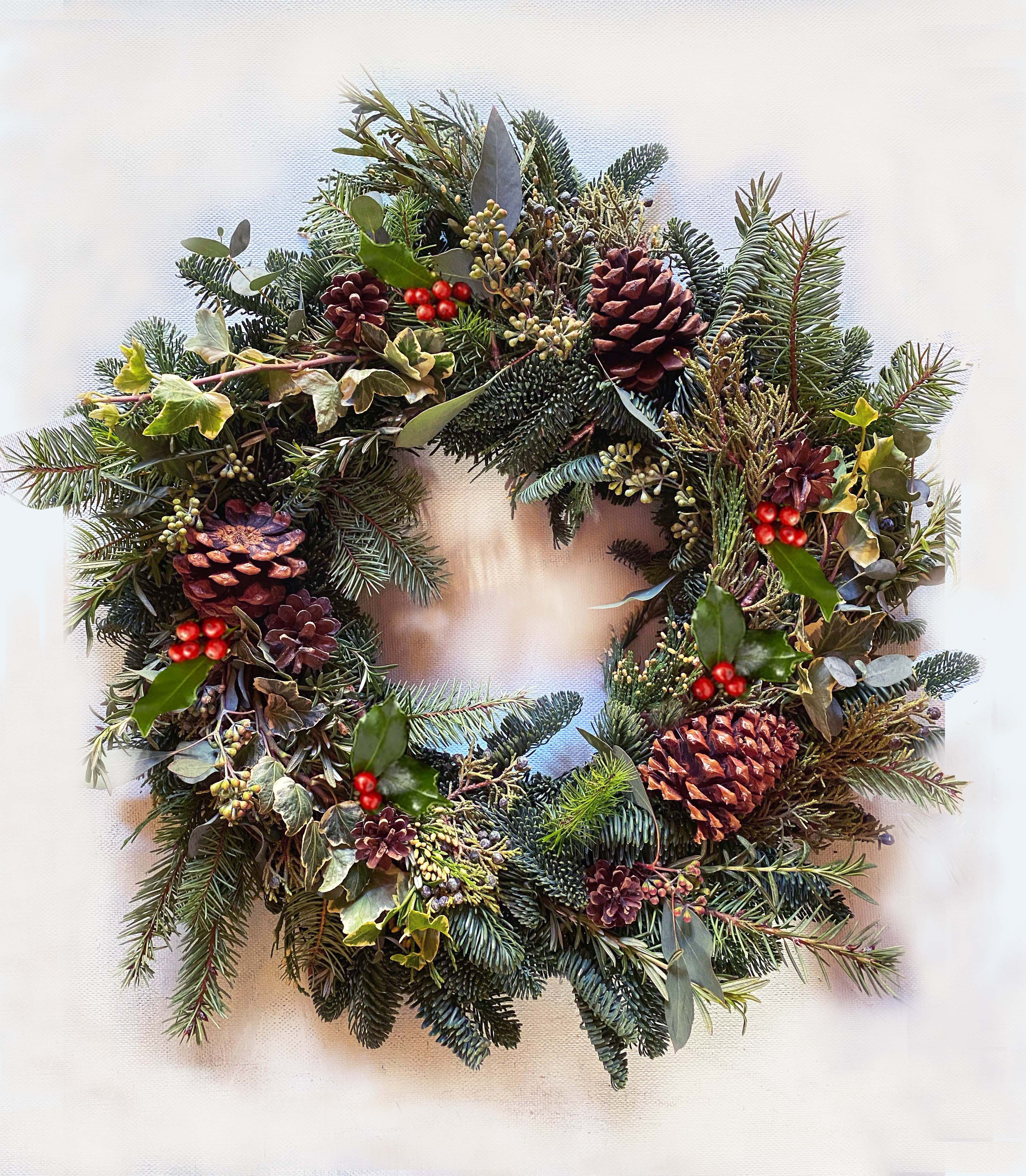 Halo Holiday Wreath - Organic and fresh 20&quot; wreath of different pines (juniper, douglas, noble), with the freshest scent of twigs of rosemary, eucalyptus and sage. Decorated with seasonal red berries from rosehip, pink peppers and beautiful  natural cones. Pretty and natural hand tied wreath for your door this Holiday season with a lovely natural scent. Choose Deluxe for a 24&quot; wreath.