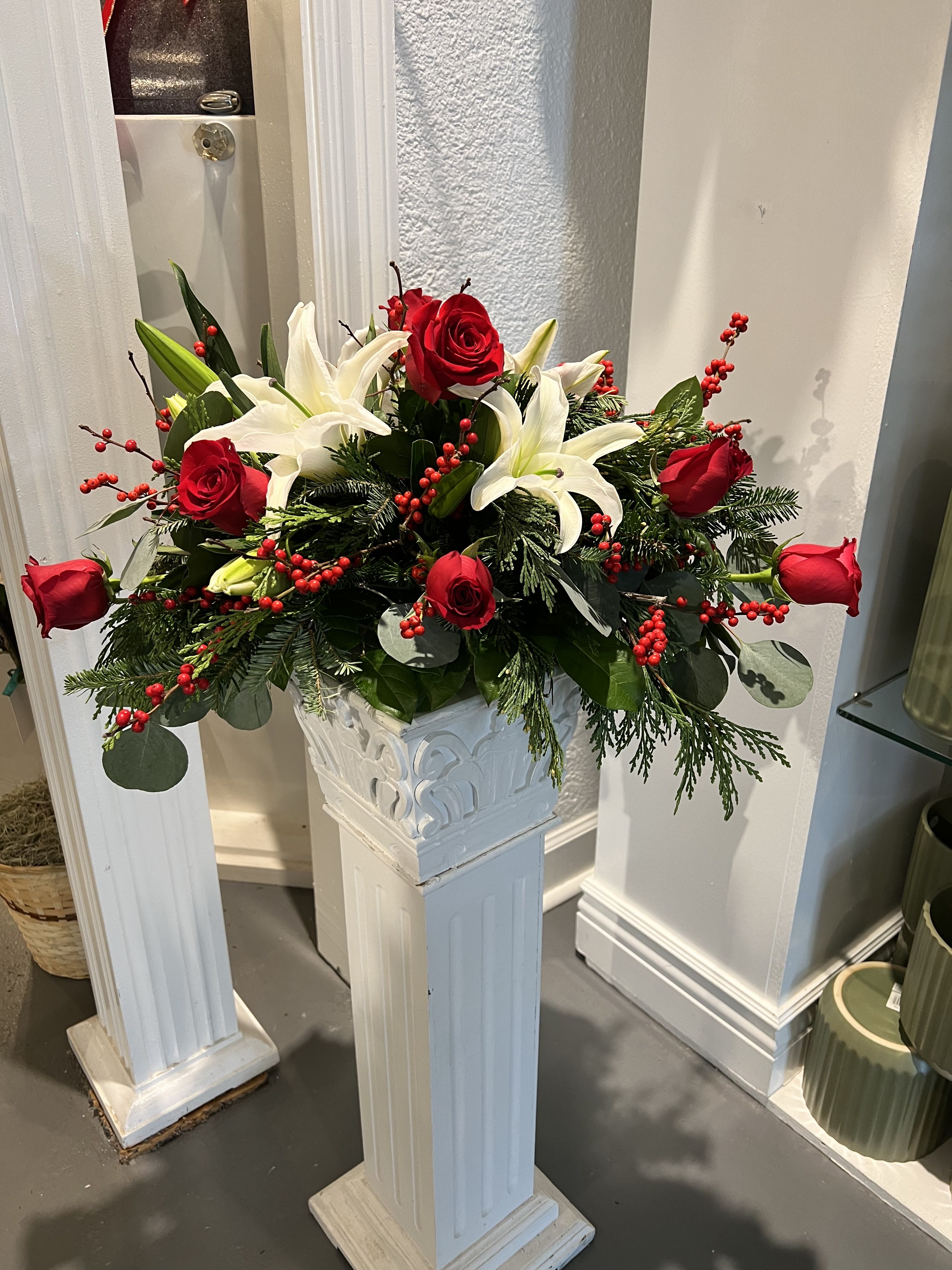 Deck The Halls Centerpiece - This centerpiece with beautiful red roses, white lilies and red berries is the perfect floral piece for your holiday table! 