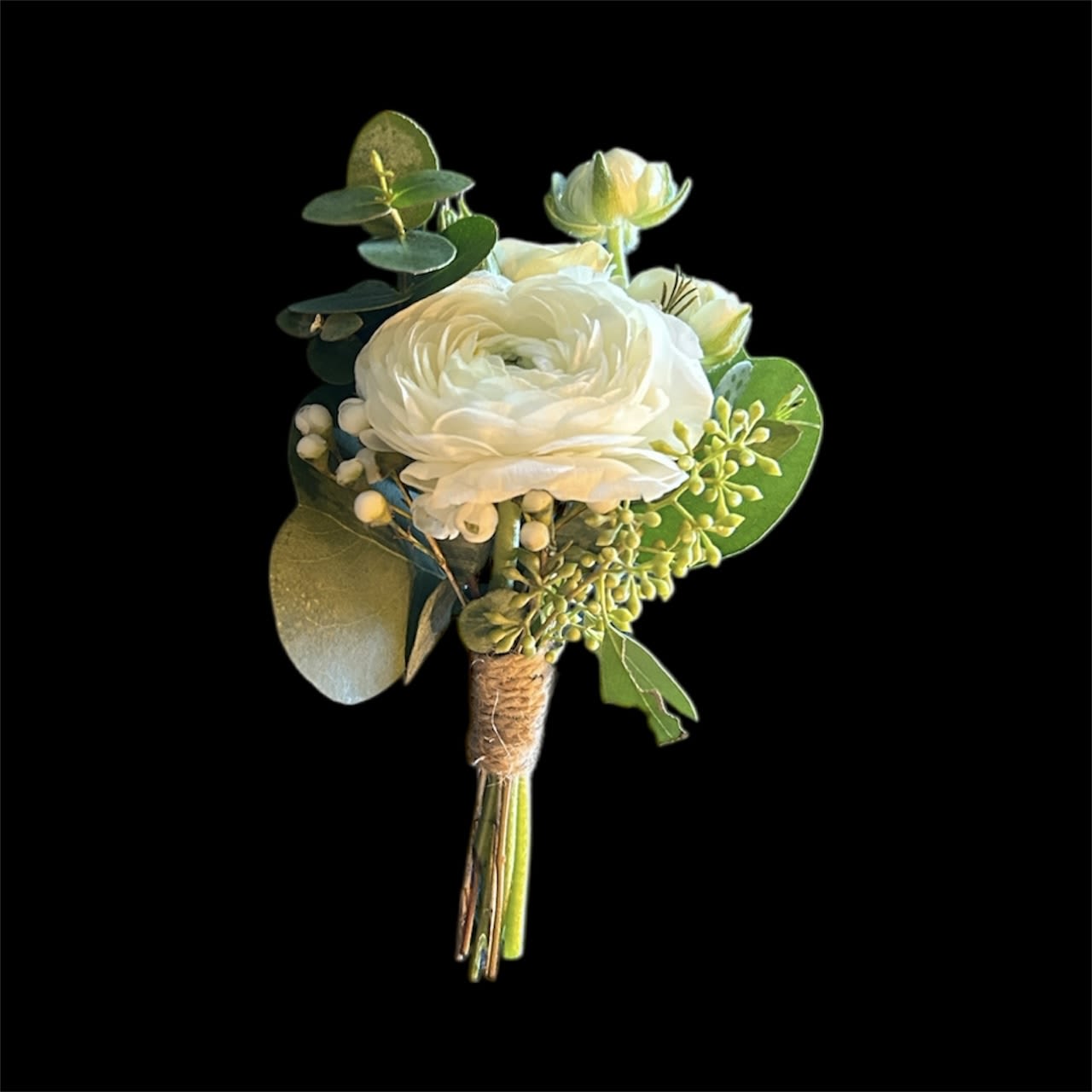 Ivory Whisper Boutonniere - A refined groom’s boutonniere featuring a white ranunculus paired with a white spray rose, accented with delicate baby’s breath, seeded eucalyptus, and parvifolia for texture and natural elegance. This classic, all-white design is perfect for romantic, formal, or garden weddings.