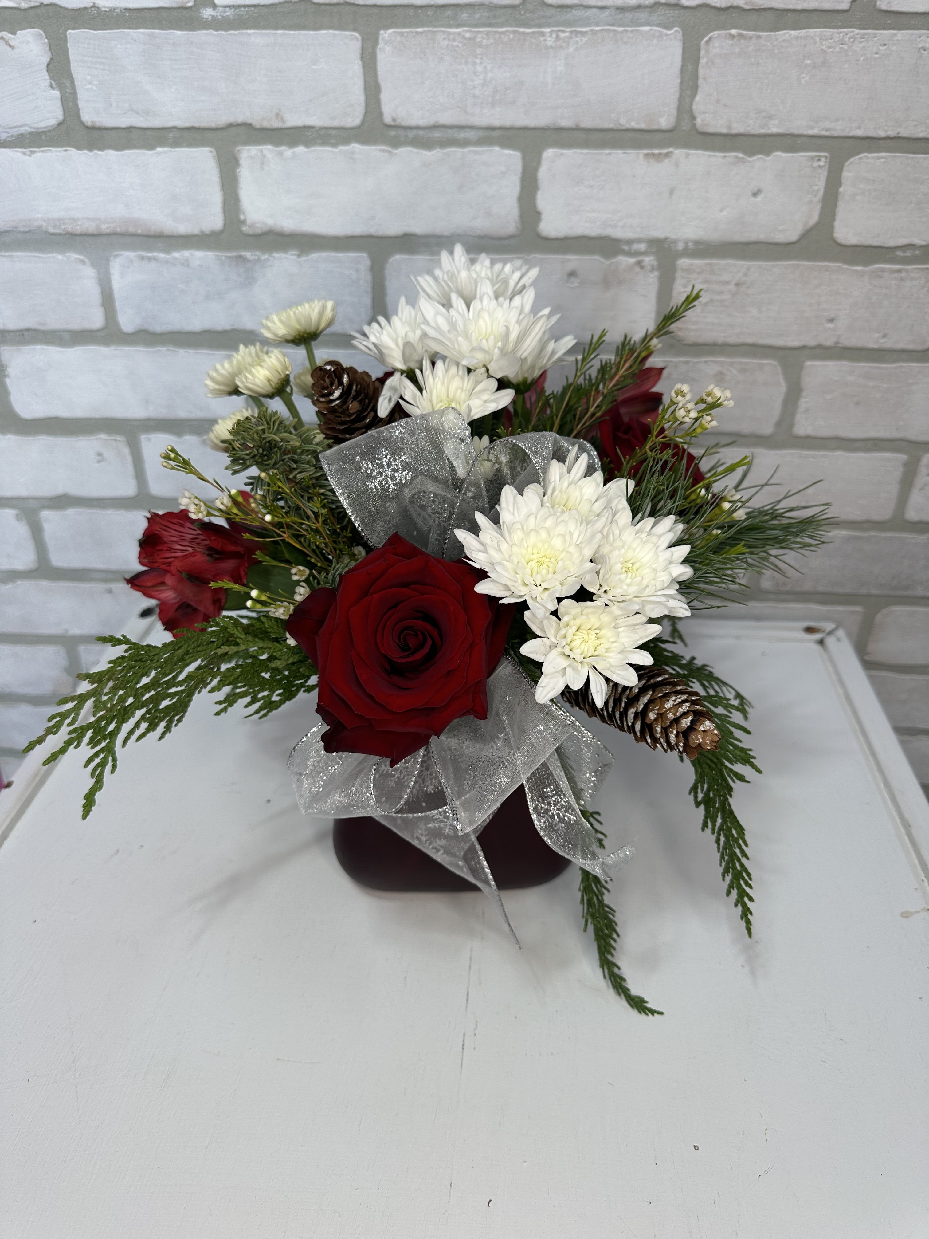 Christmas Wish - A festive arrangement of roses, alstromeria lilies, white poms, and Christmas greens