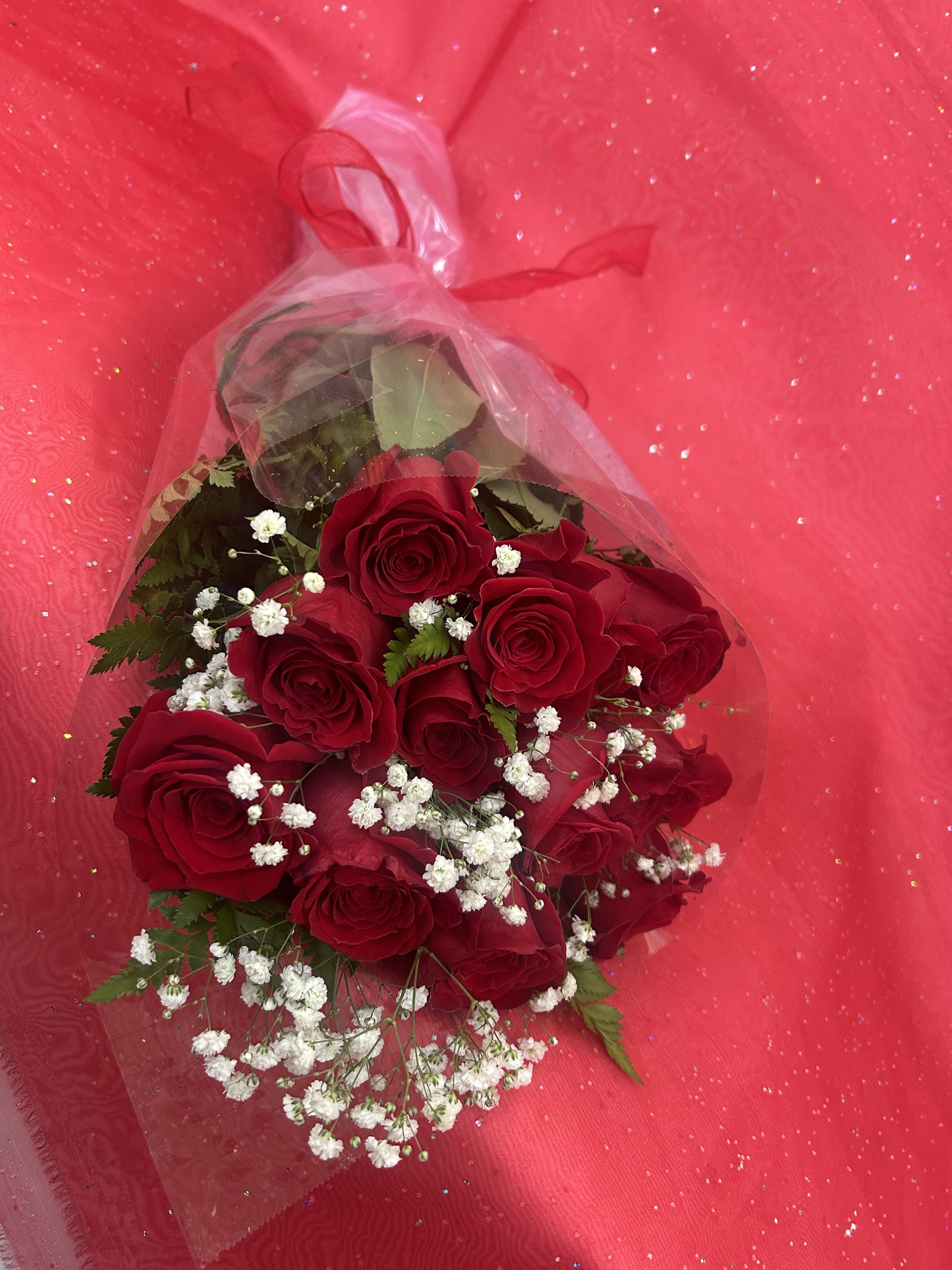 Red Dozen Roses Wrapped - Red roses the sign of love, passion and romance. Roses, filler flower and greens wrapped together so that someone special can arrange them in their own vase at home. Perfect gift for showing your love.