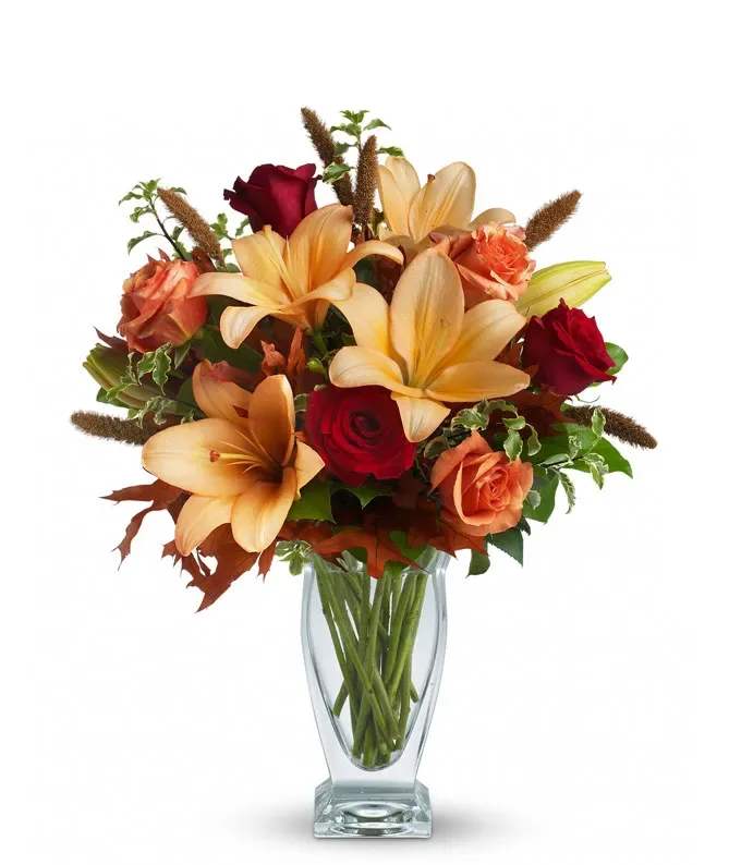 Fall Fantasia  - Roses, lilies and oak leaves create a fantasy of fall flowers. Send this tall, elegant arrangement to wish someone a happy autumn, a happy birthday or a joyous Thanksgiving. The warm color palette makes a stylish seasonal statement. 