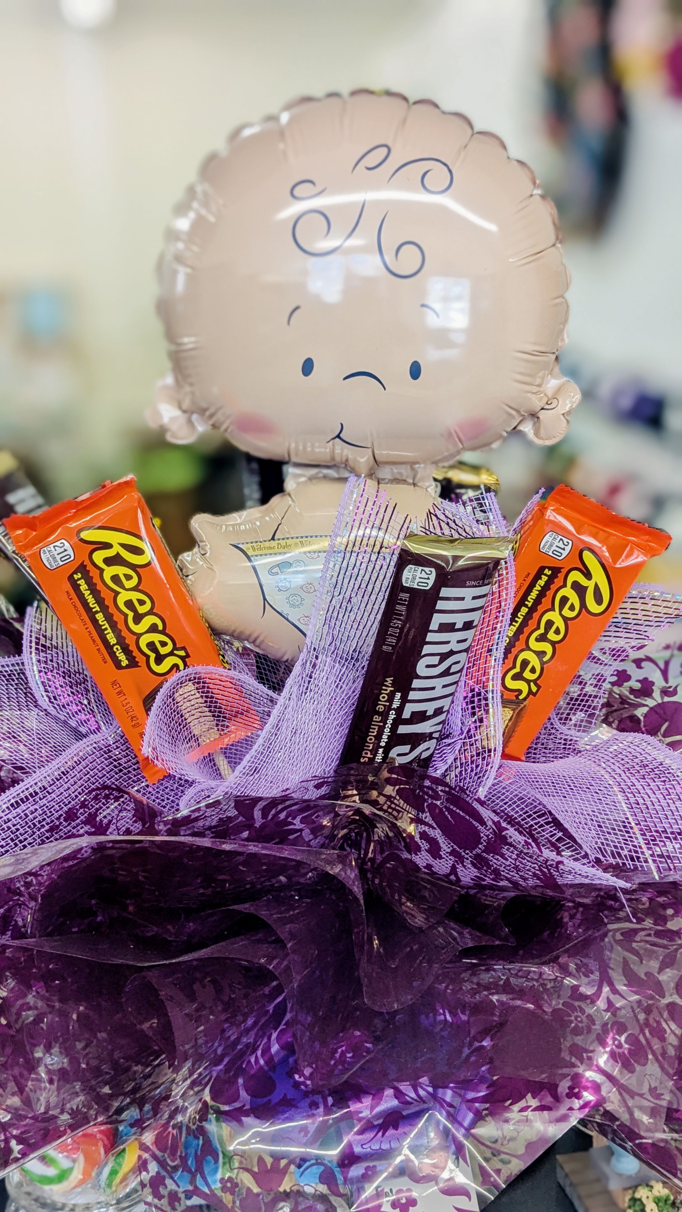 New Baby Candy Bouquet - A vase filled to the brim with delicious bite sized candy. Topped with full sized candy and a Balloon. Bound to bring a smile to anyone's face. *candy subject to change, please leave a special instruction if PEANUT ALLERGY*