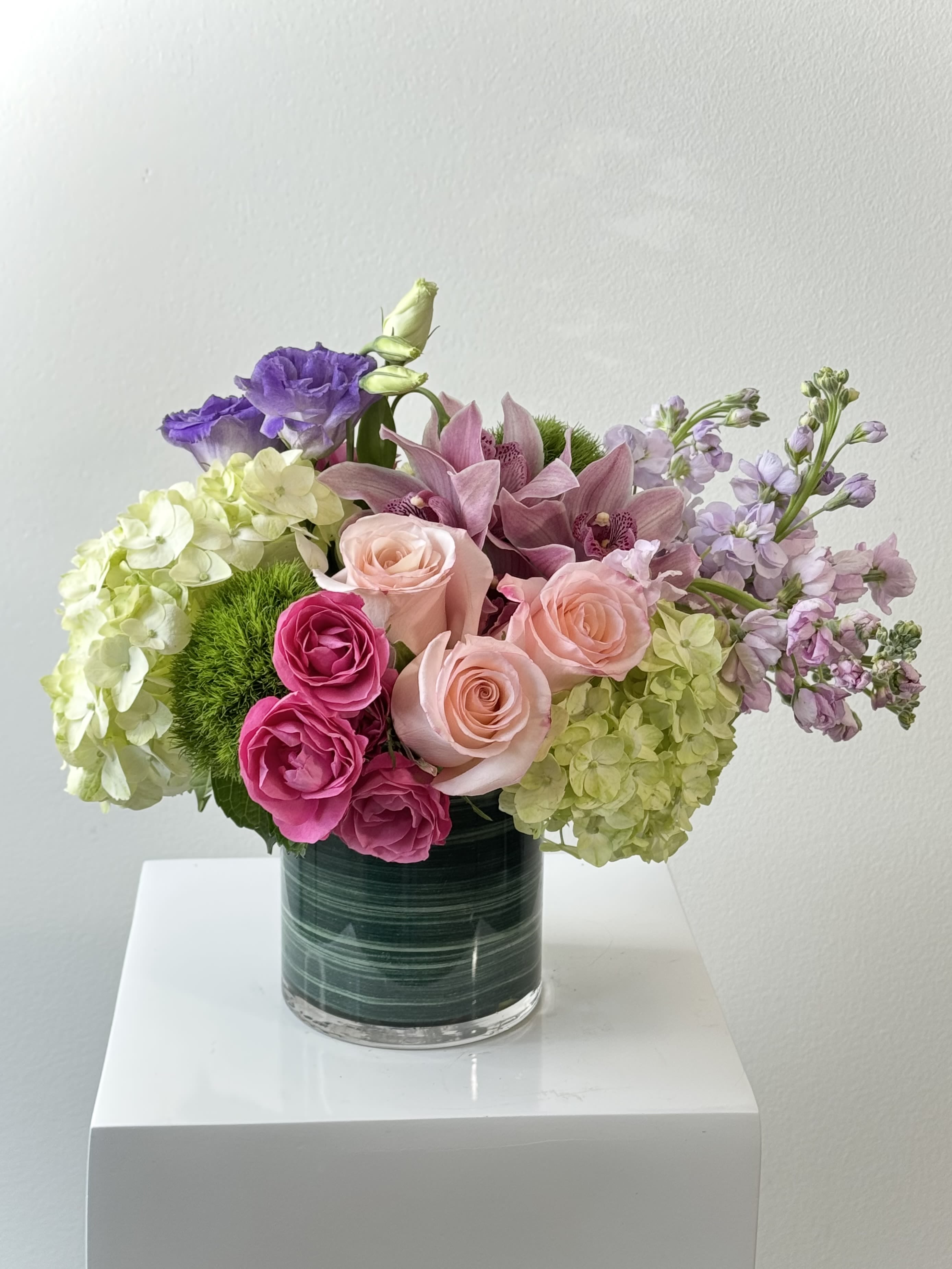The Favorite Bouquet - Discover why &quot;The Favorite Bouquet&quot; consistently tops our best-seller list: a luxurious, hand-crafted masterpiece that blends soft romance with modern sophistication. This stunning arrangement begins with voluminous green hydrangeas, creating a cloud-like foundation that instantly captivates. Delicate purple lisianthus adds airy texture and subtle charm, while sweetly scented lavender stock fills the air with its calming fragrance. At the heart bloom classic pink roses surrounded by vibrant fuchsia spray roses for an extra touch of playful energy. Exotic pink cymbidium orchids lend an unmistakable touch of luxury and tropical elegance, their graceful arches drawing the eye throughout the design. Finishing the bouquet are whimsical dianthus balls, adding perfect round accents and incredible depth. Expertly arranged by our master florists using only premium, freshest-cut flowers, this bouquet radiates joy and thoughtfulness. Ideal for anniversaries, birthdays, saying &quot;I love you,&quot; thank you gestures, or simply brightening someone’s day.  What’s inside:  Lush green hydrangeas  Delicate purple lisianthus  Fragrant lavender stock  Timeless pink roses  Vibrant fuchsia spray roses  Luxurious pink cymbidium orchids  Playful dianthus balls  Keywords: luxury flower bouquet delivery, pink and purple bouquet, green hydrangea arrangement, romantic flowers, best-selling bouquet, anniversary flowers, birthday flower delivery, pink cymbidium orchid bouquet, customer favorite flowers.