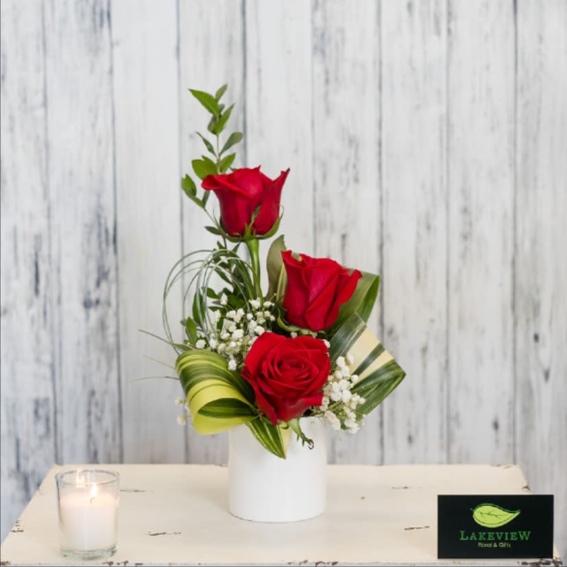 Priceless - Three velveteen red roses coupled with modern aspidistra leaves and classic tuffs of babies breath. An updated classic!   Approximate Dimensions: 13&quot; H x 7&quot; W