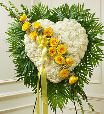Always in My Heart Floral Heart - Yellow - This solid heart standing spray, accented with a slash of beautiful yellow roses, is a loving symbol of your sympathy and support. White carnations, yellow roses,