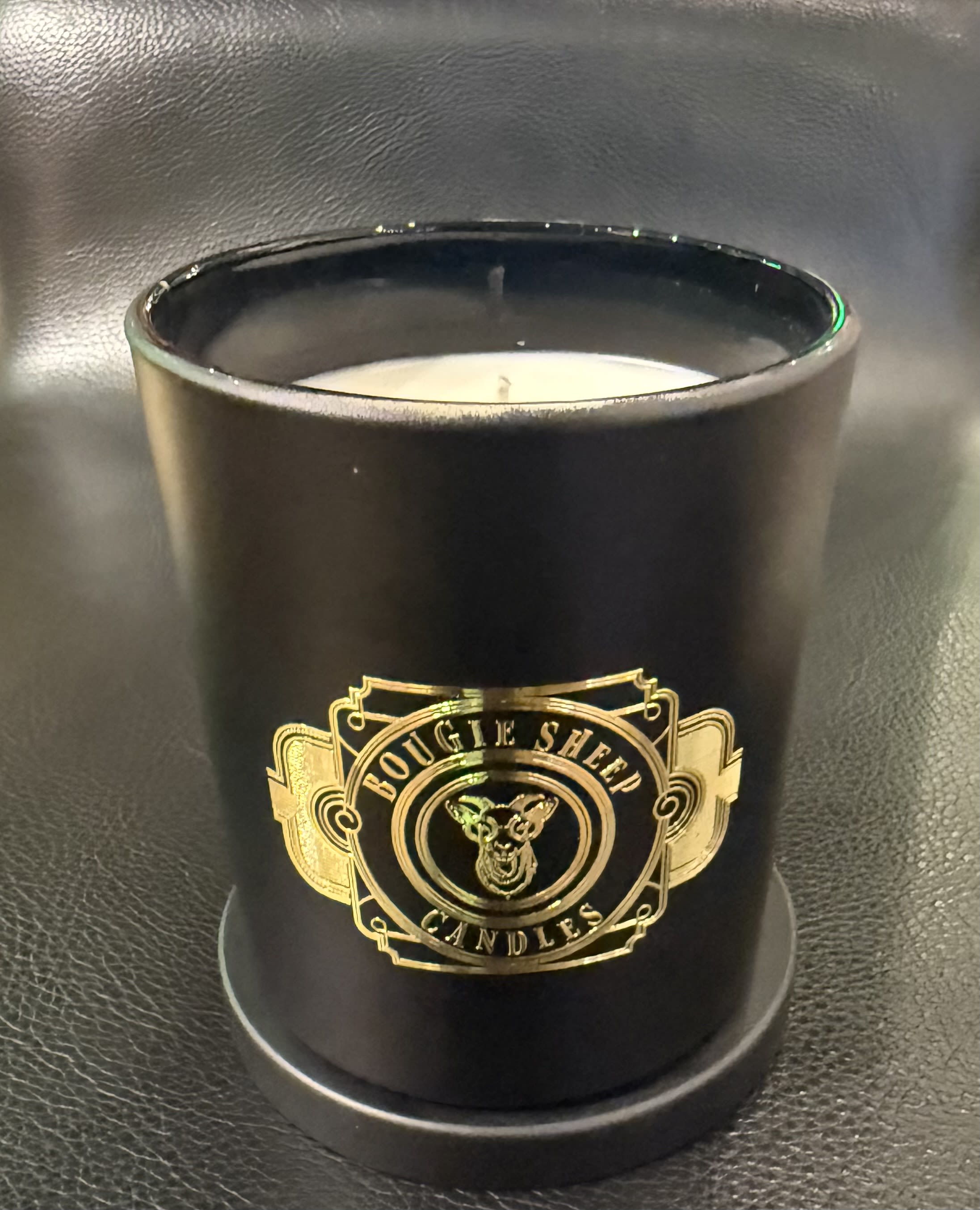 Longing Bougie Sheep Candle 10 oz - Hand-poured in a 10 oz vessel, Longing opens with a bright whisper of bergamot, a citrus glow that flickers like a thought you can’t quite release. The heart blooms into night jasmine, soft and magnetic, drawing you inward with its quiet pull. Grounded by teakwood and warm, intimate musk, the scent settles into a slow, resonant burn—deep, nostalgic, and undeniably sensual.  This is the fragrance of moments that stay with you: the warmth of a shoulder you once leaned on, the stillness after a door closes, the sweetness of what might have been.  Warm. Wooded. Emotional. A 10 oz candle for the heart’s most beautiful unrest.