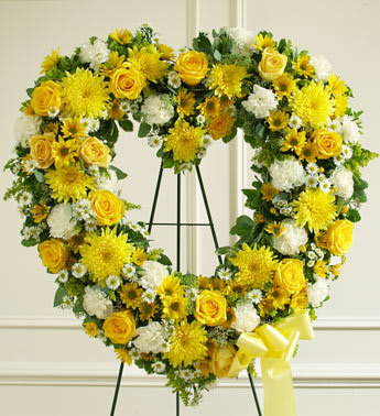 Always Remember Floral Heart Tribute - Yellow - Convey your deepest condolences and undying love with this beautiful arrangement. Yellow and white flowers such as roses, cremones, carnations and more Open heart with oasis in mache, tied to the wire easel with satin ribbon Sent directly to the funeral home by family and friends. 