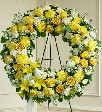 Serene Blessings Yellow Standing Wreath - Standing wreath arrangement of fresh yellow and white flowers such as roses, Asiatic lilies, carnations, mums and more. Accented by salal, seeded eucalyptus and more. Appropriate for family, friends and business associates to send directly to the funeral home. 