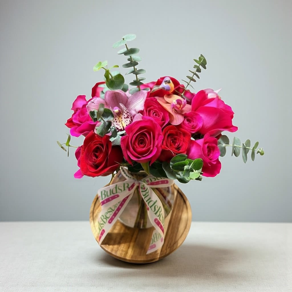 Rosy Orchid Romance - This arrangement includes purple cymbidium orchids, red roses, &amp; pink roses. Rosy Orchid Romance is the romantic gift for Valentine's Day or Anniversary.   Vase Subject to Change